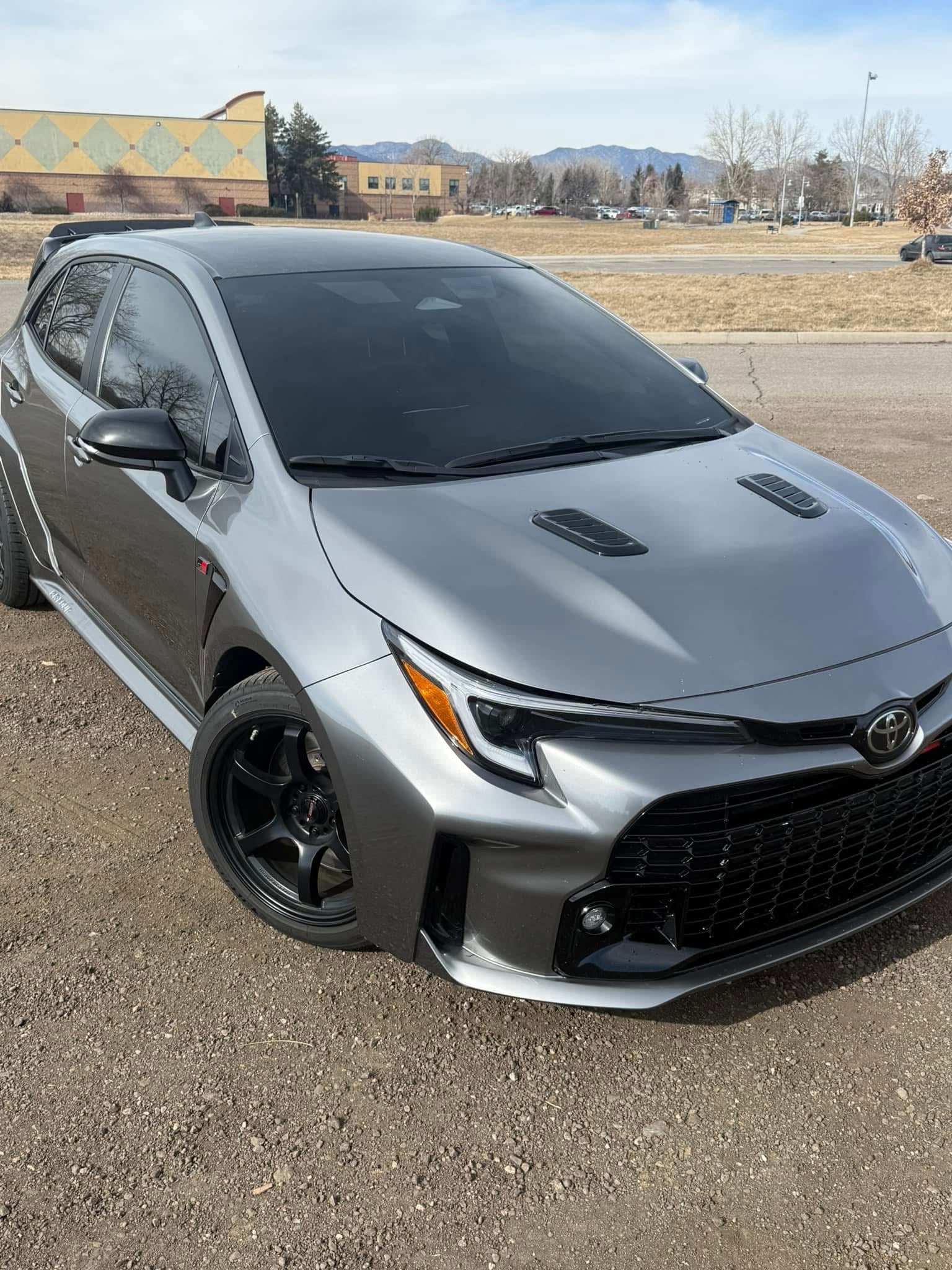 Front three-quarter view of a gray GR Corolla with hood scoop