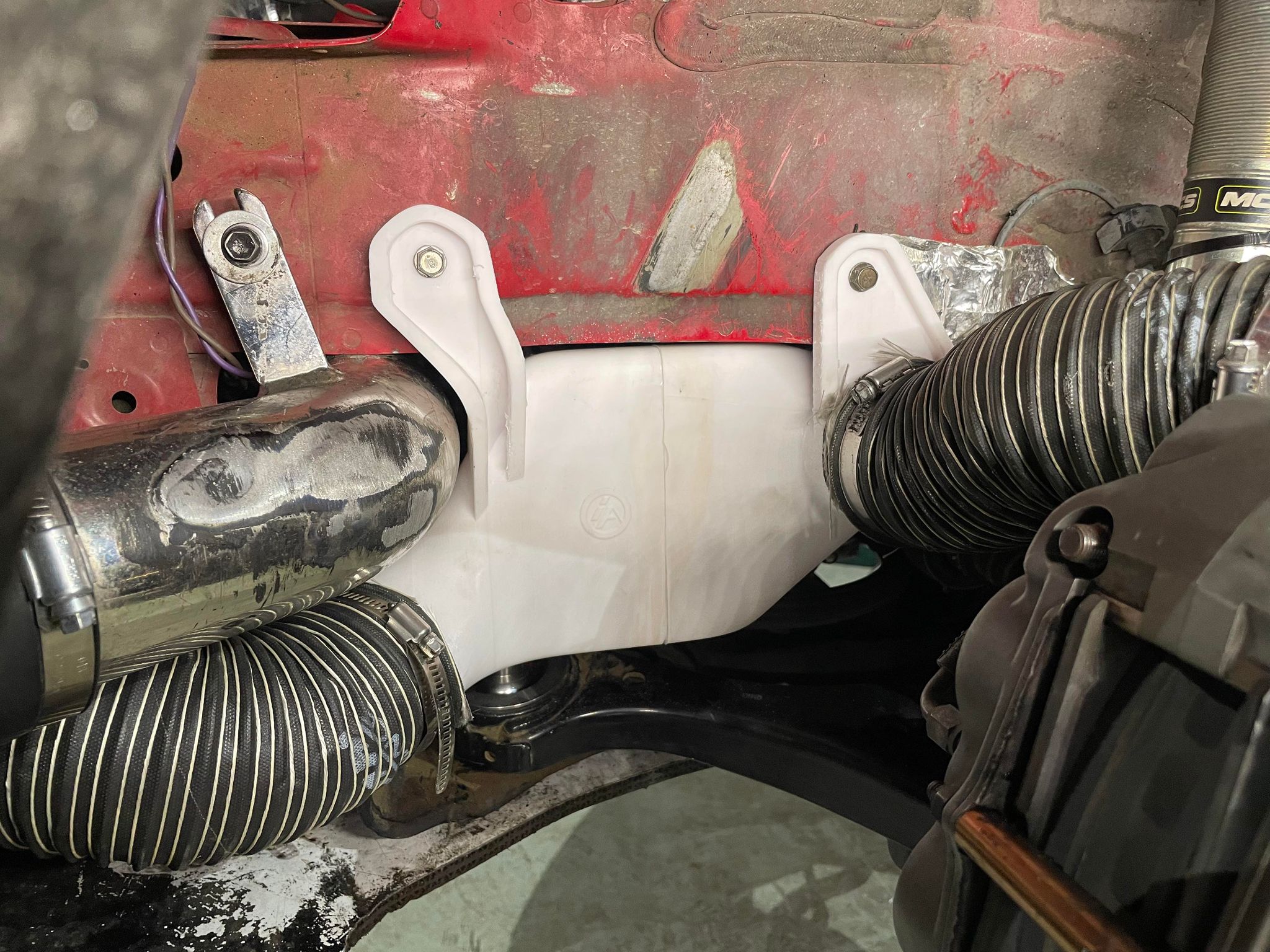 Pancake duct mount installed behind the fender liner on a red Civic Coupe race car