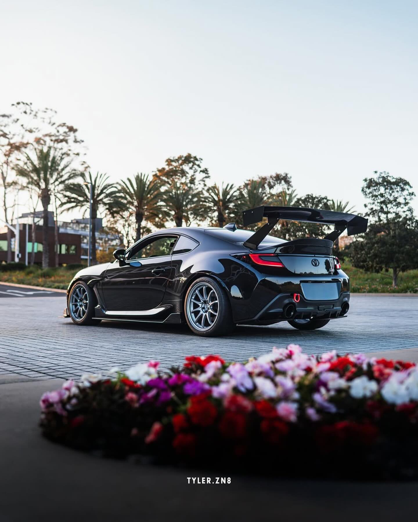 Rear view of a black BRZ ZN8 with GT wing parked outside a building