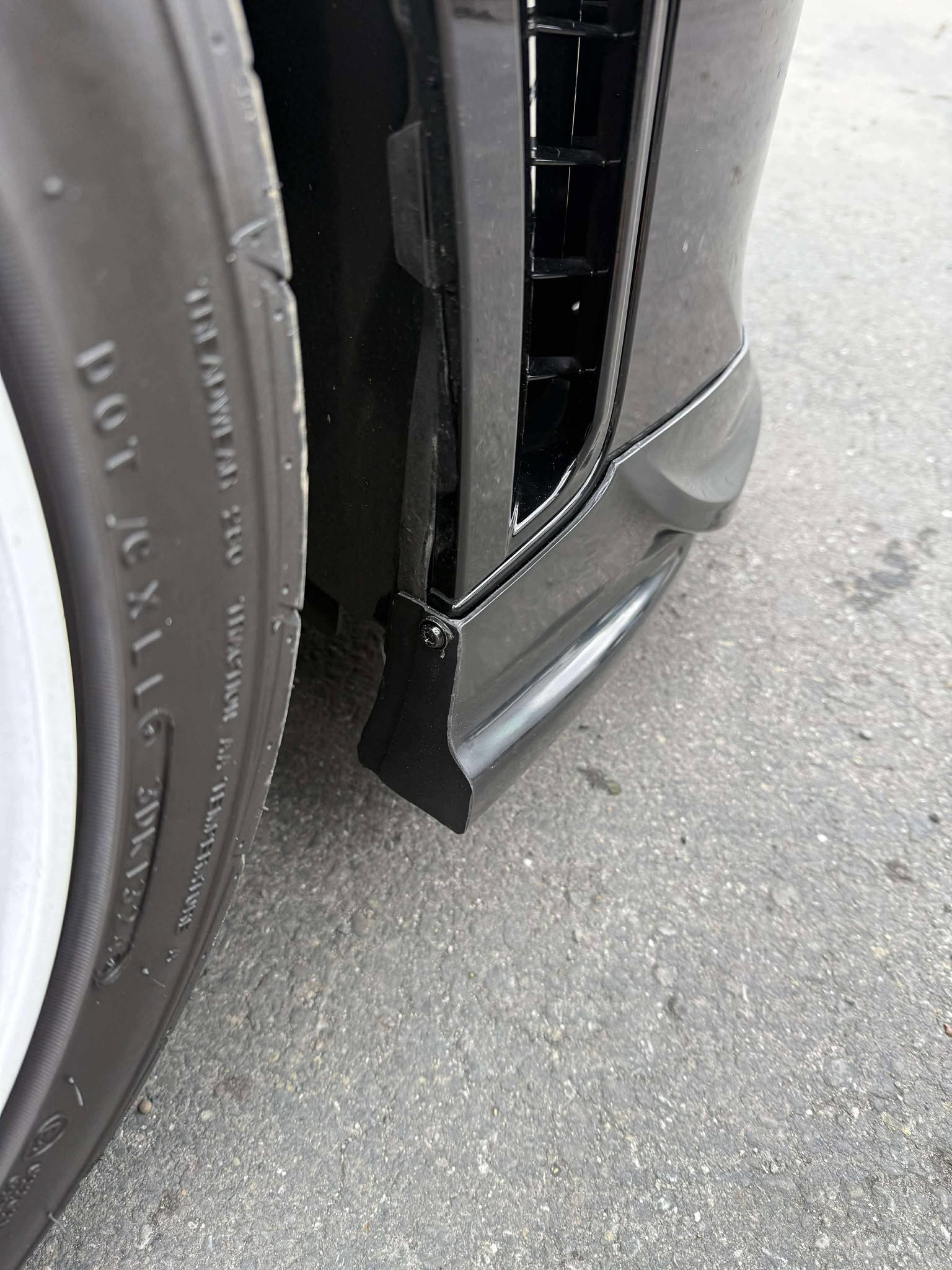 Close-up front three-quarter view of a black GR Corolla Kouki with front lip in a parking lot