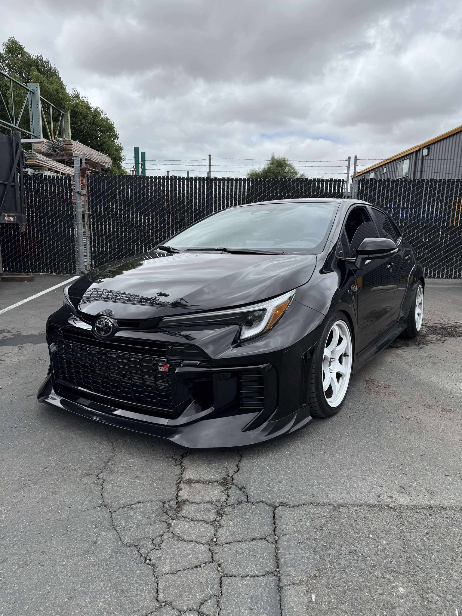 Close-up of the front lip corner and headlight on a black GR Corolla Kouki