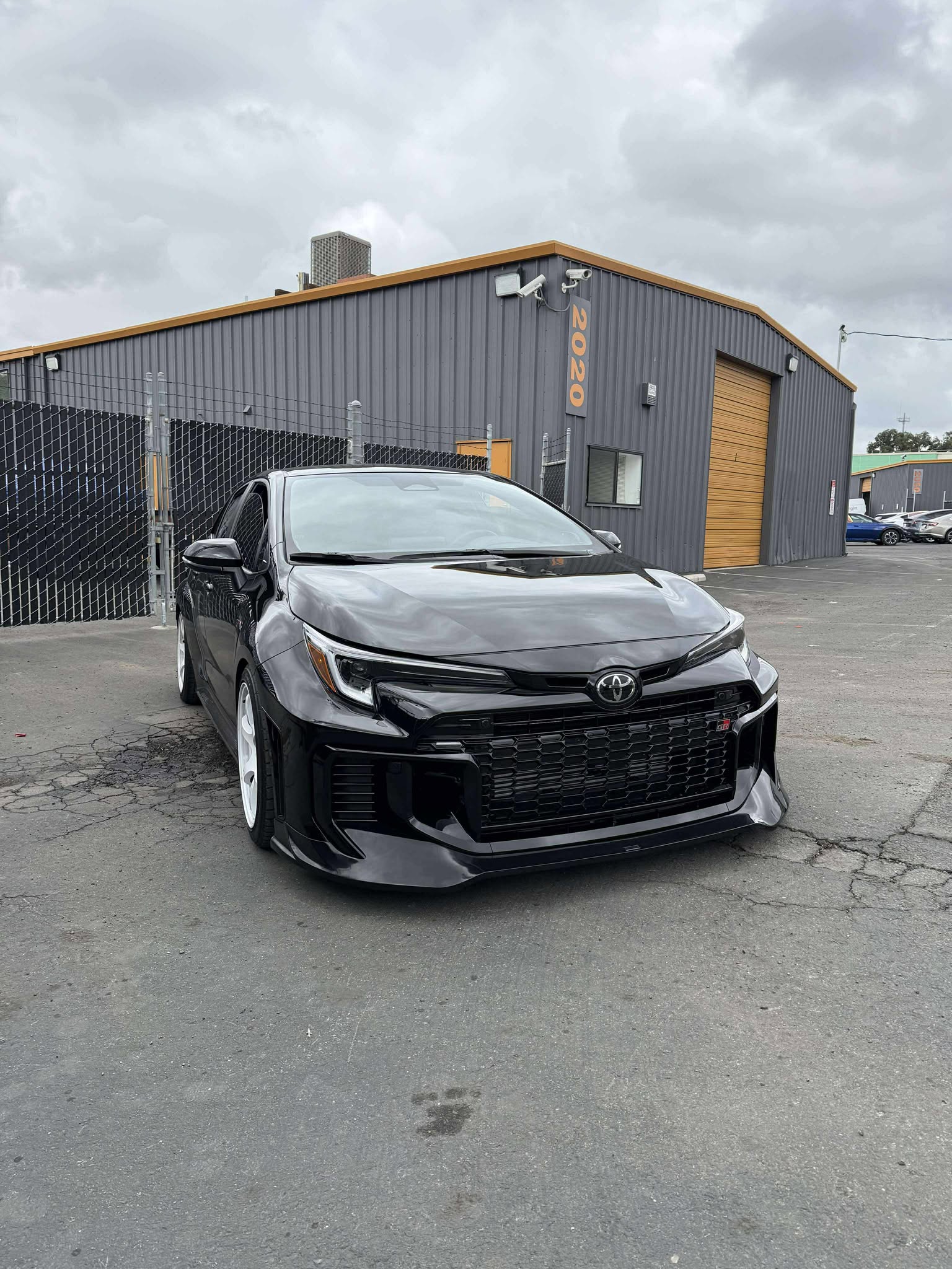 Front-on view of a black GR Corolla Kouki with front lip parked outdoors