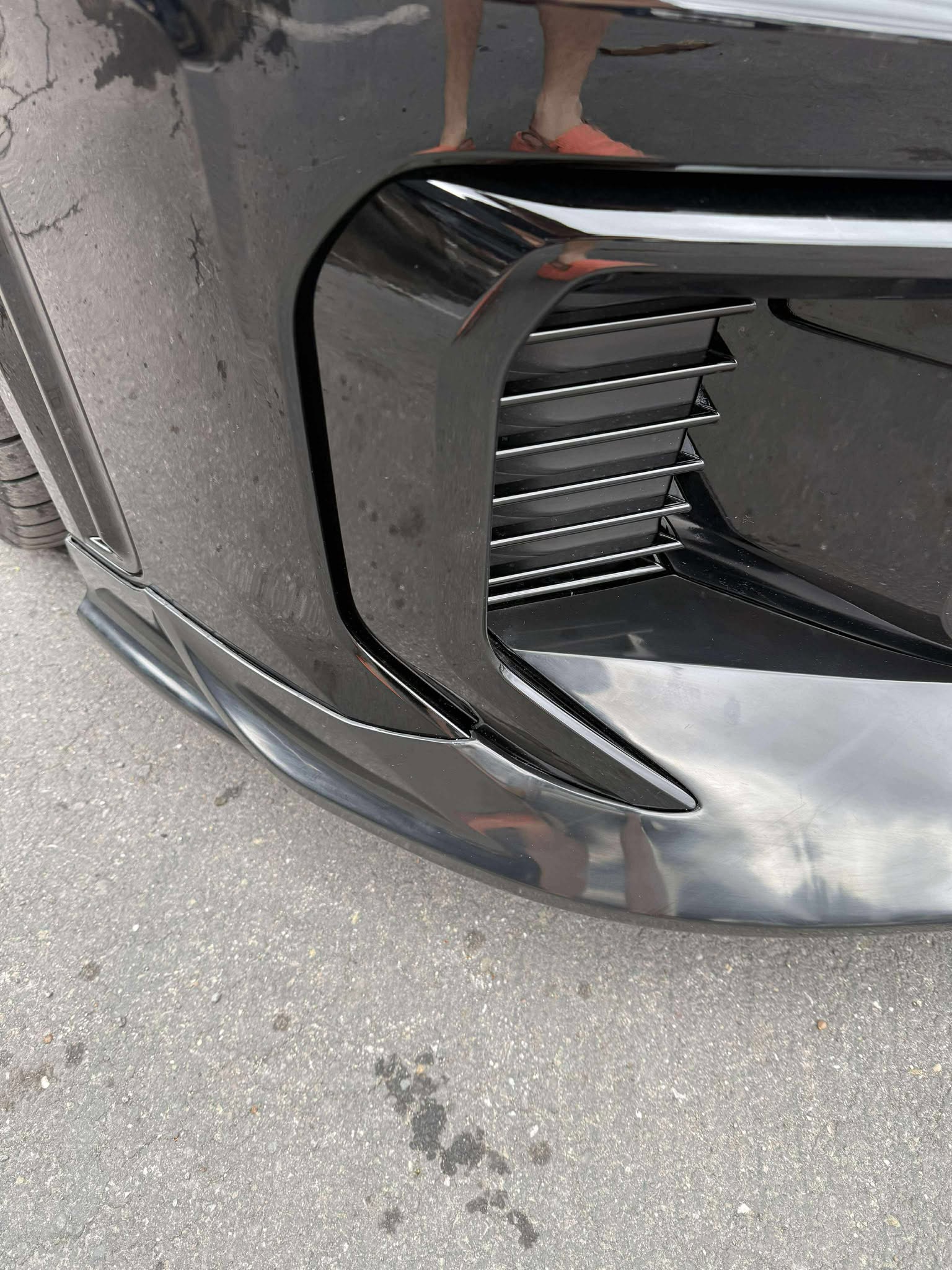 Front three-quarter view of a black GR Corolla Kouki with front lip and headlights on