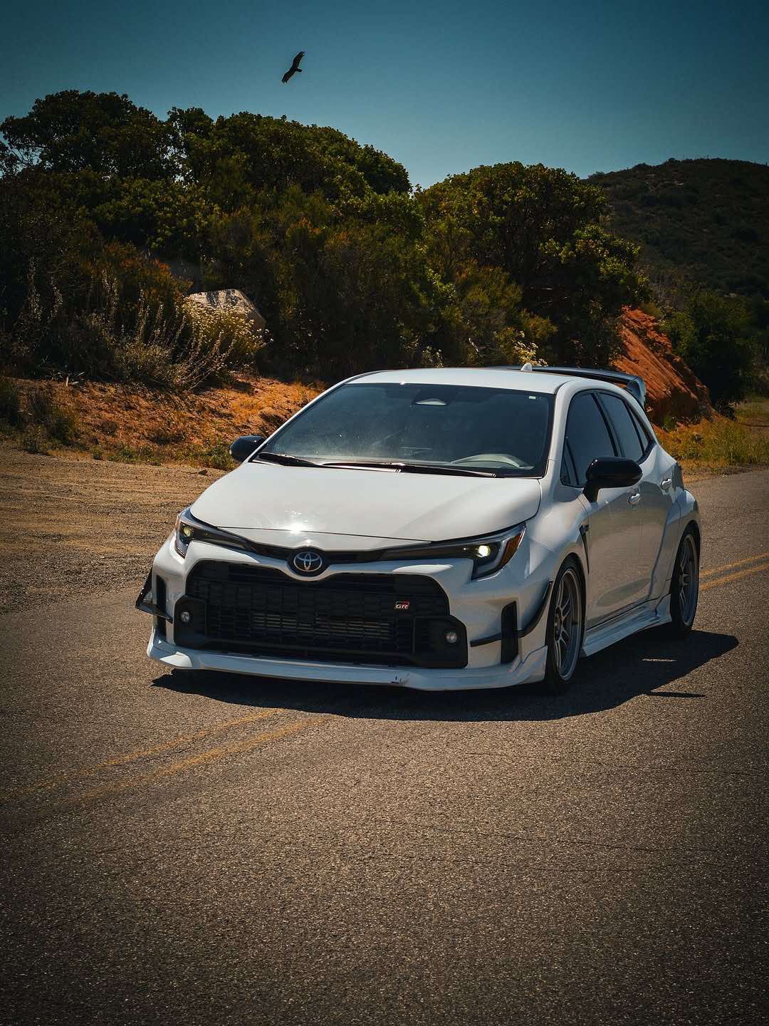 Front three-quarter view of a black GR Corolla with front lip at a car show