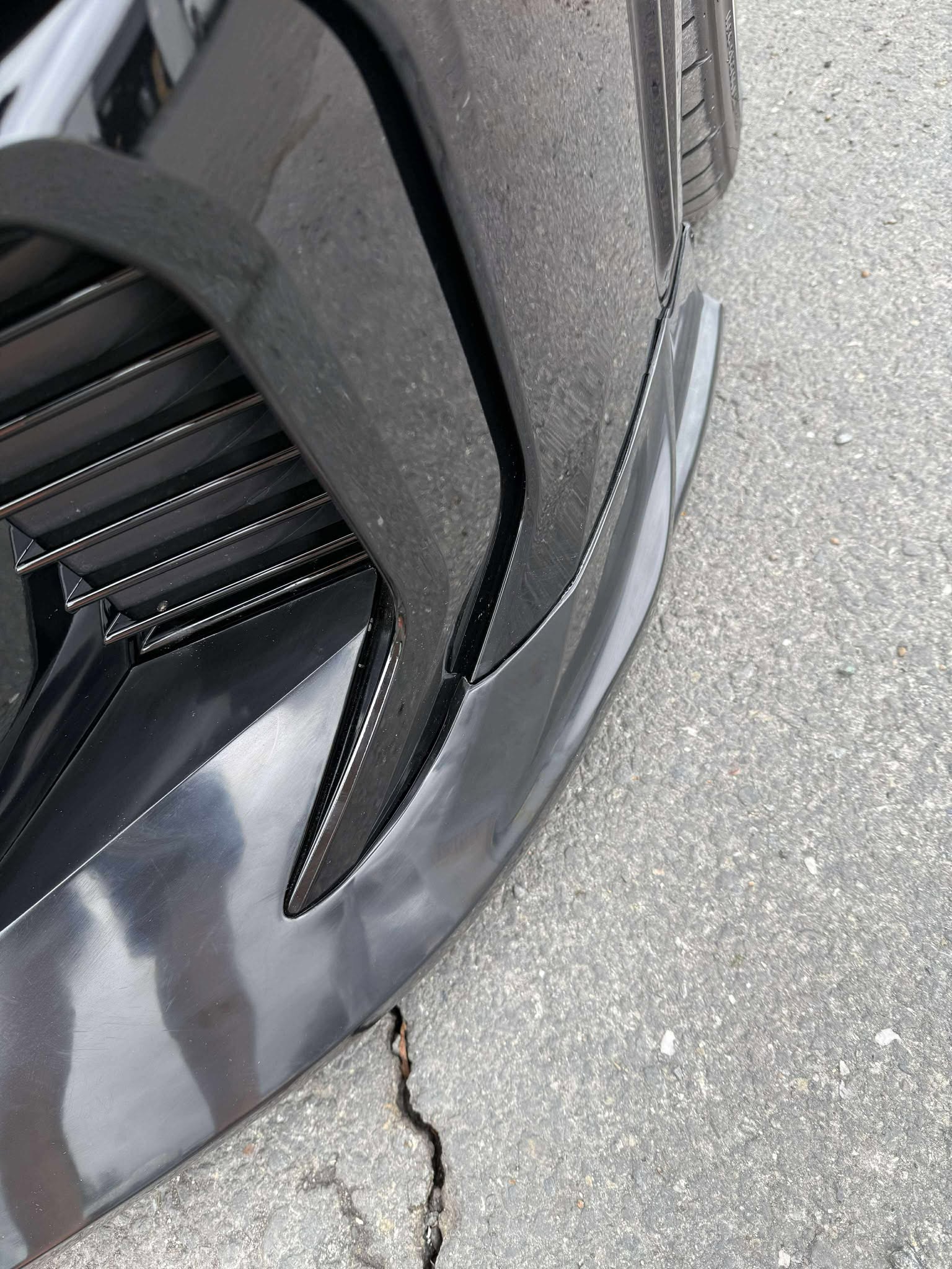 Close-up underside detail of the front lip mounting hardware on a GR Corolla Kouki