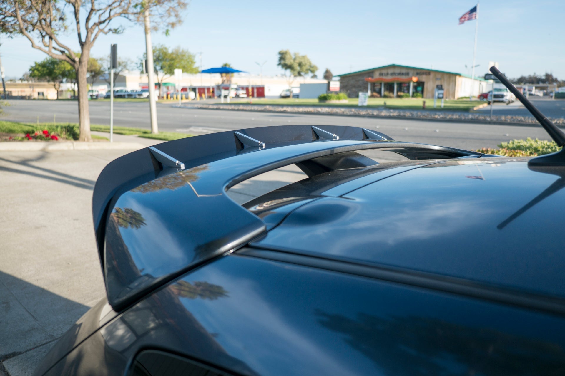 Close-up of the spoiler extension mounted on a blue Mazdaspeed3 Gen1 roofline