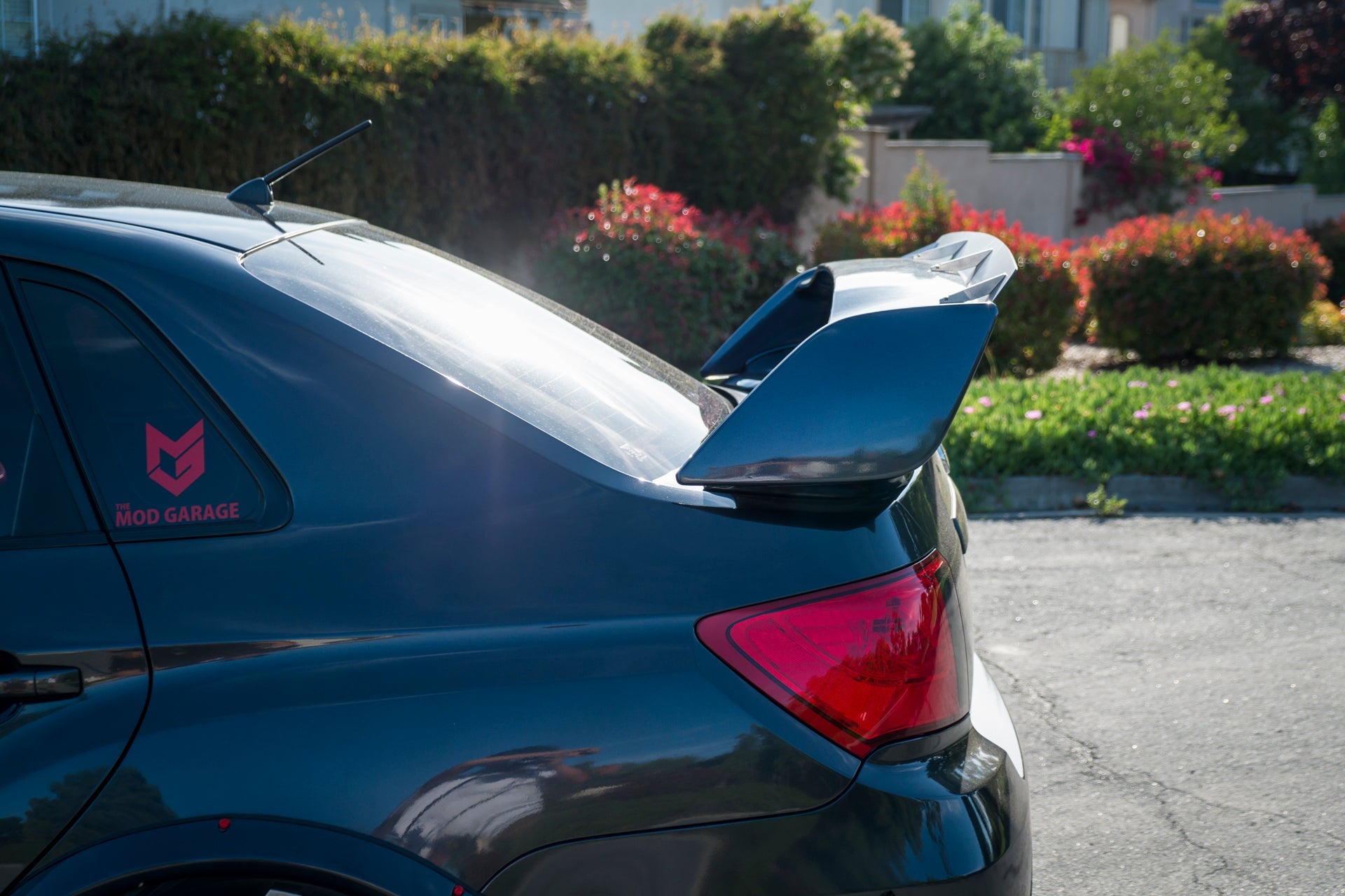 Side rear view of a gray STI Sedan showing the spoiler extension profile