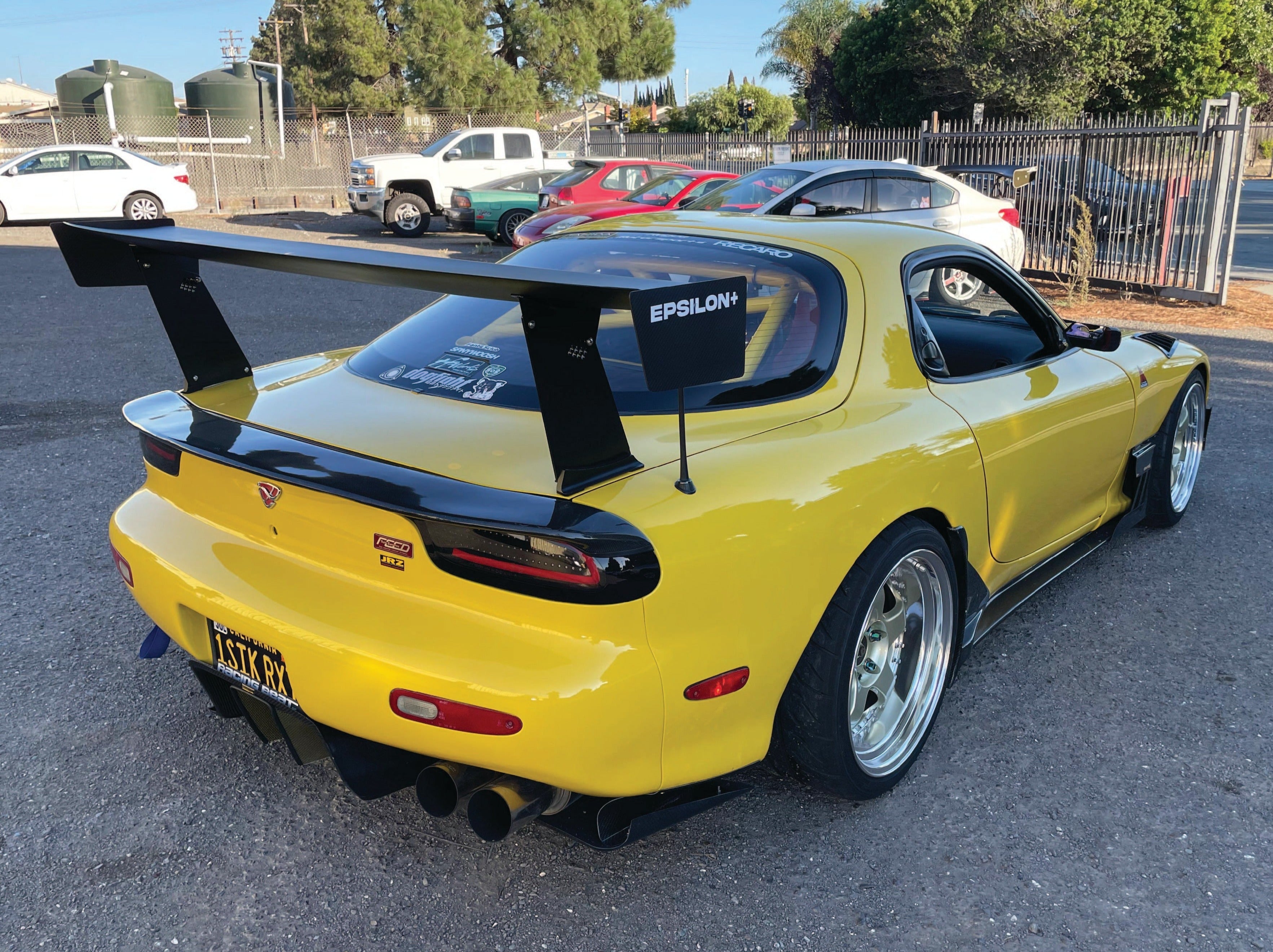 Rear three-quarter view of a yellow Mazda RX-7 FD with GT wing