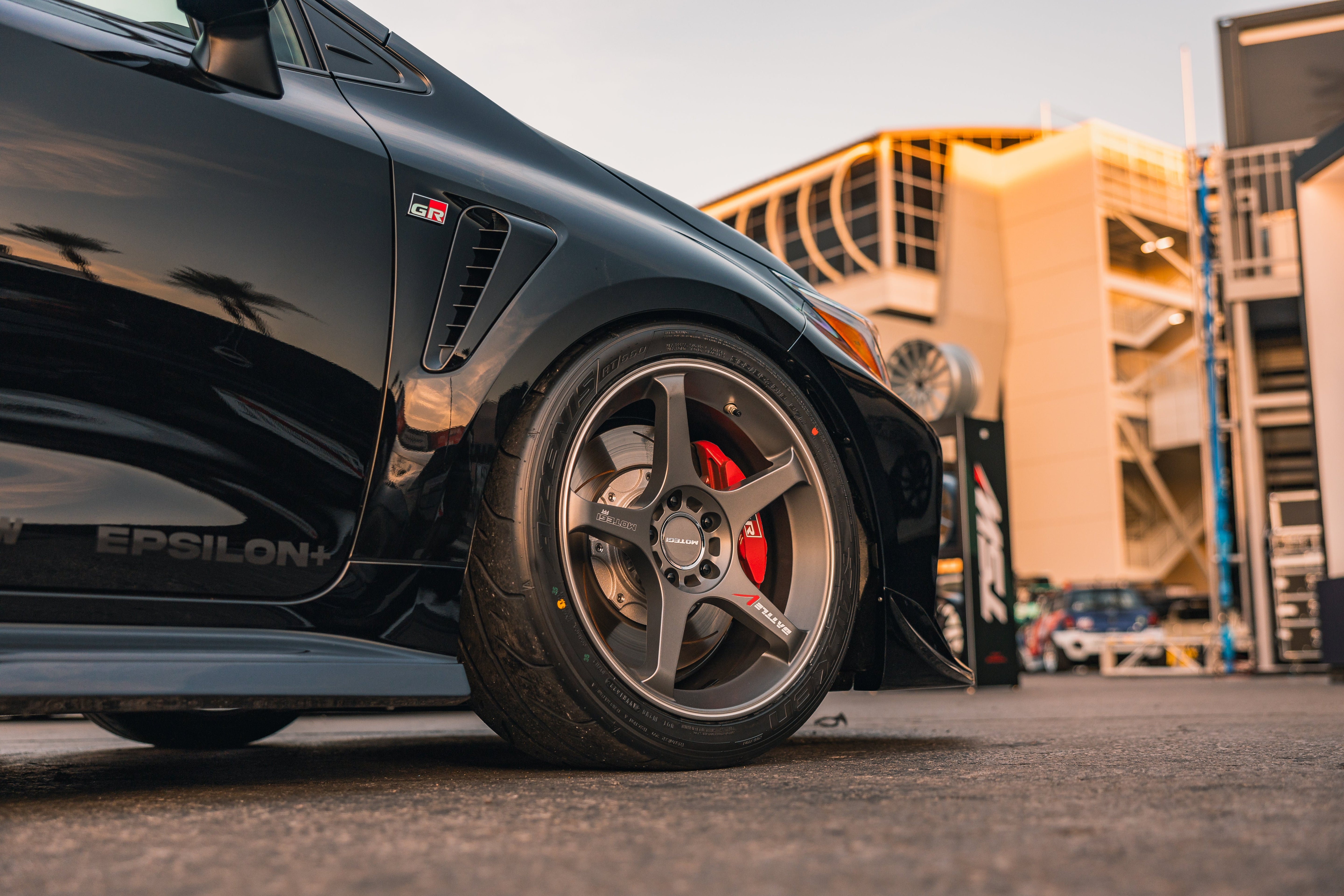 Low-angle close-up of a black GR Corolla wheel and side skirt with Epsilon+ branding