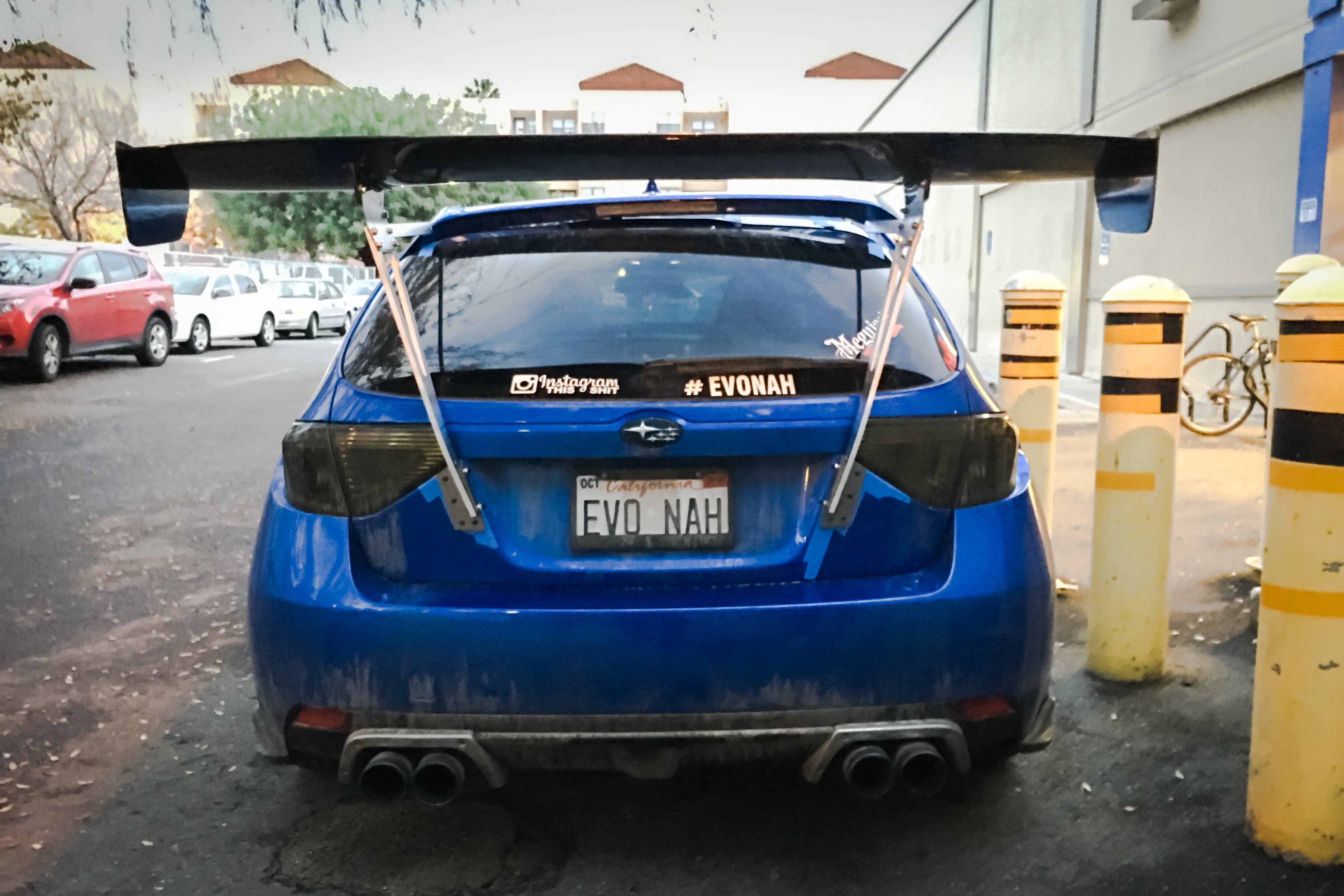 Rear view of a blue Subaru Impreza Hatchback GR with GT wing in a parking garage