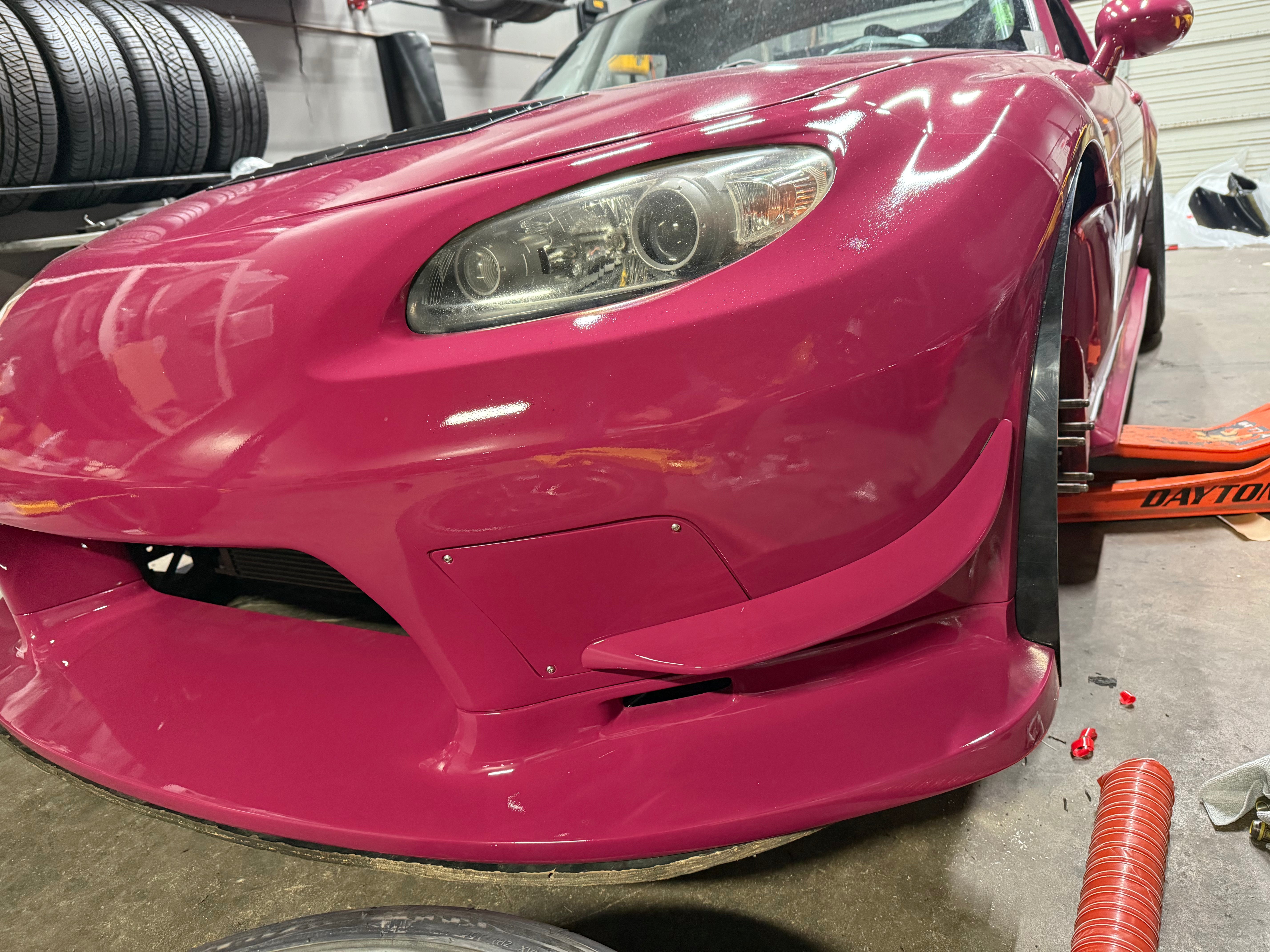 Front view of a pink Miata NC with the Epsilon bumper and brake duct inlets installed