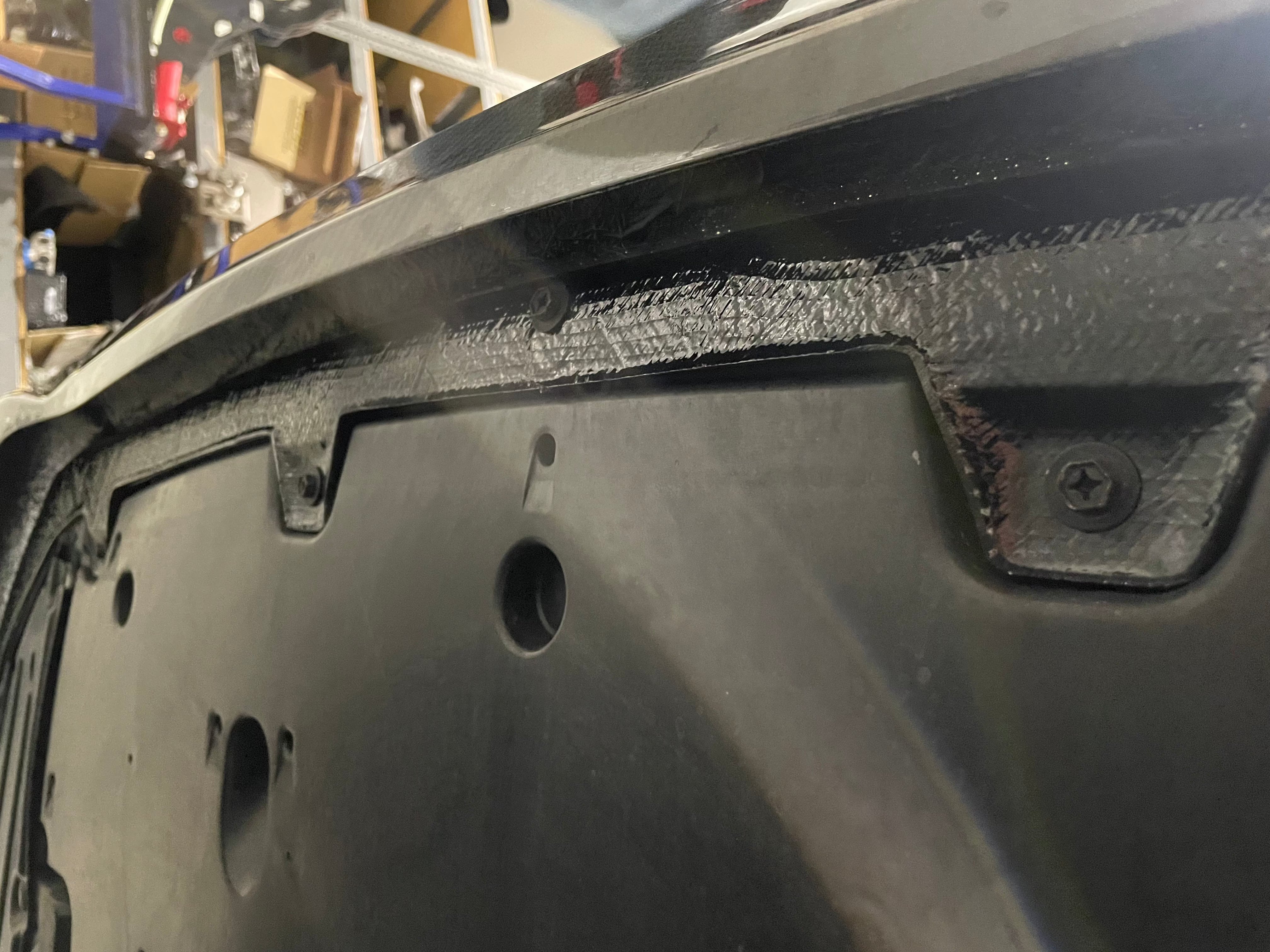 Close-up of the carbon fiber front lip corner detail during fitment