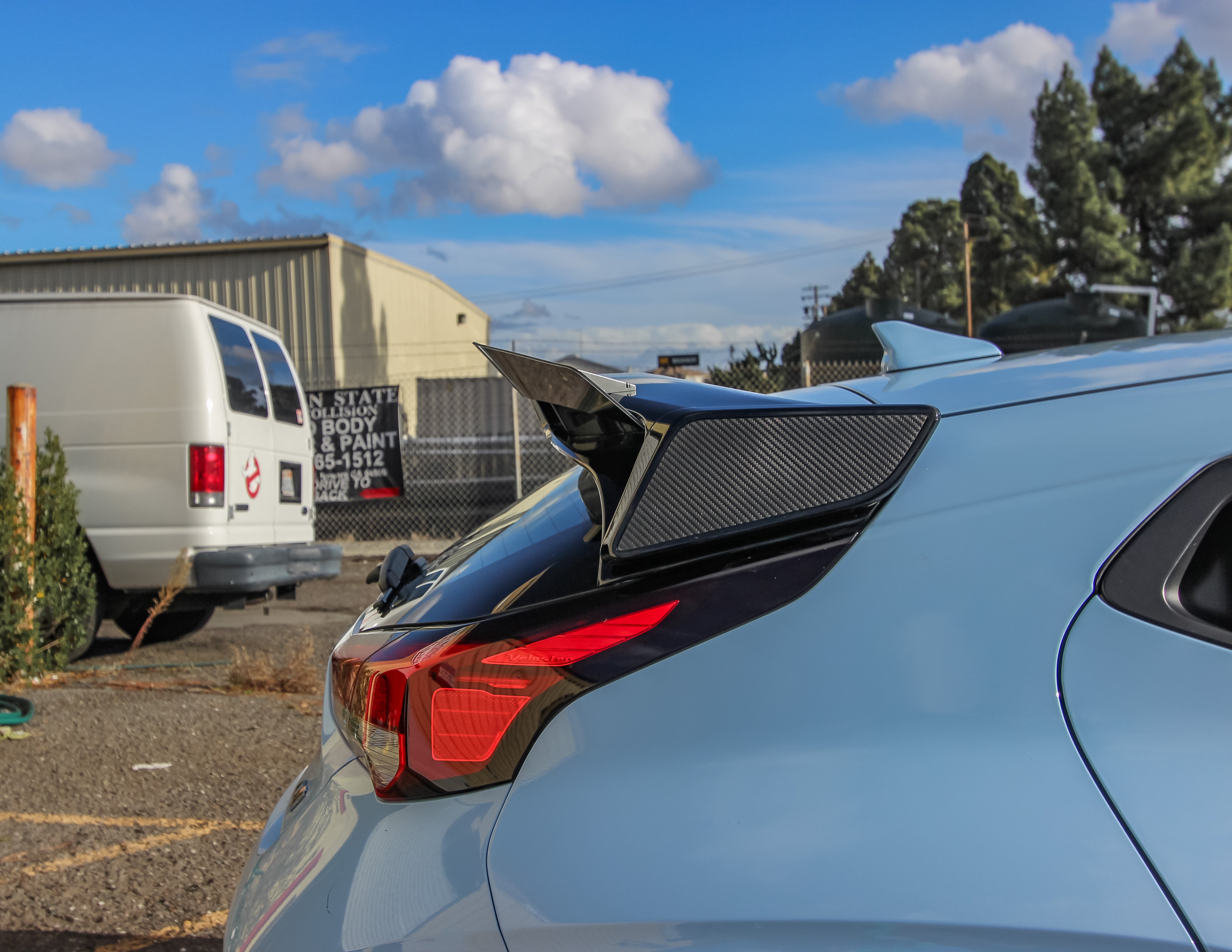 Rear three-quarter view of a light blue Veloster N JS with spoiler extension outdoors