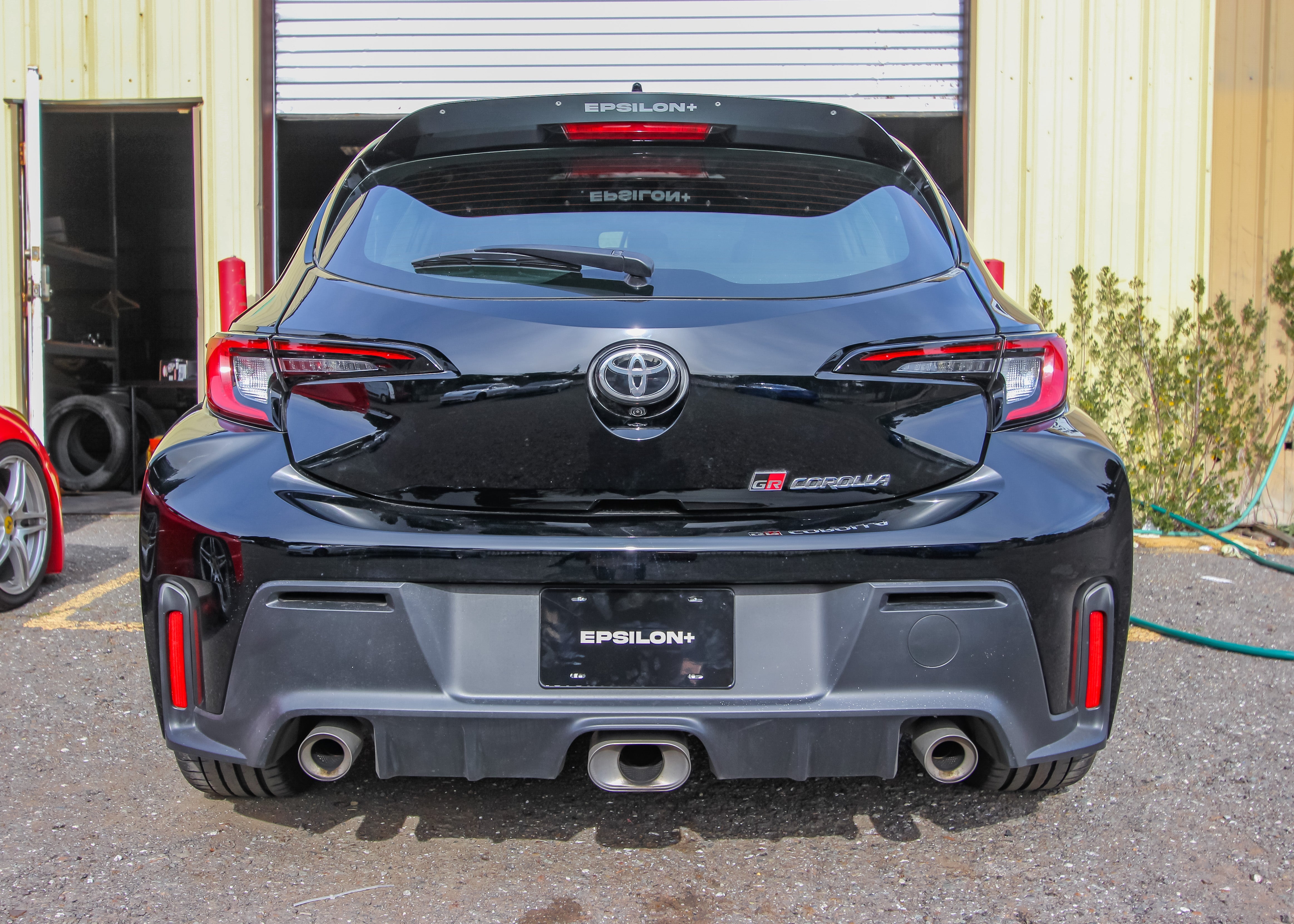 Rear view of a black GR Corolla showing the spoiler extension and taillights