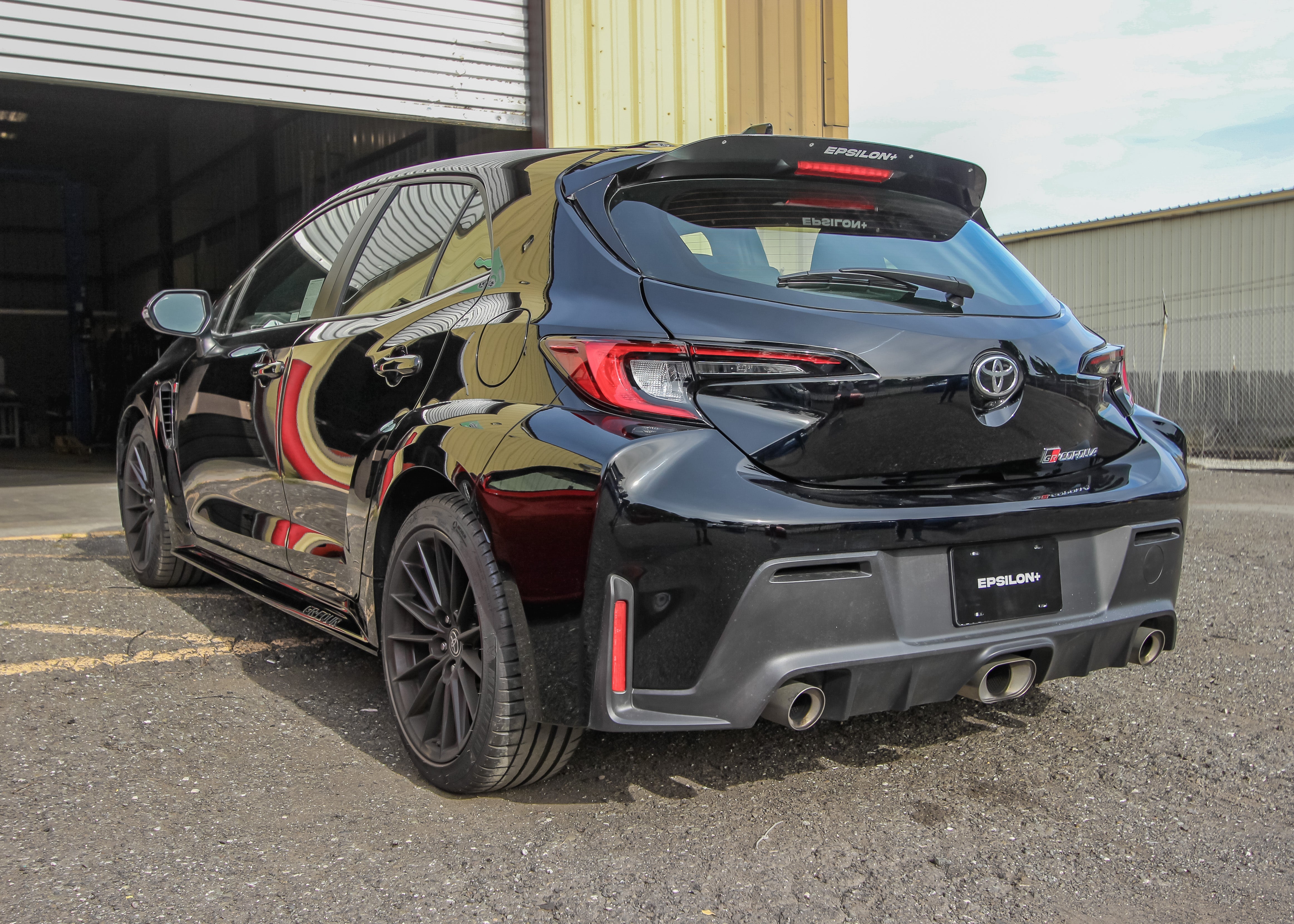 Rear three-quarter view of a black GR Corolla with spoiler extension