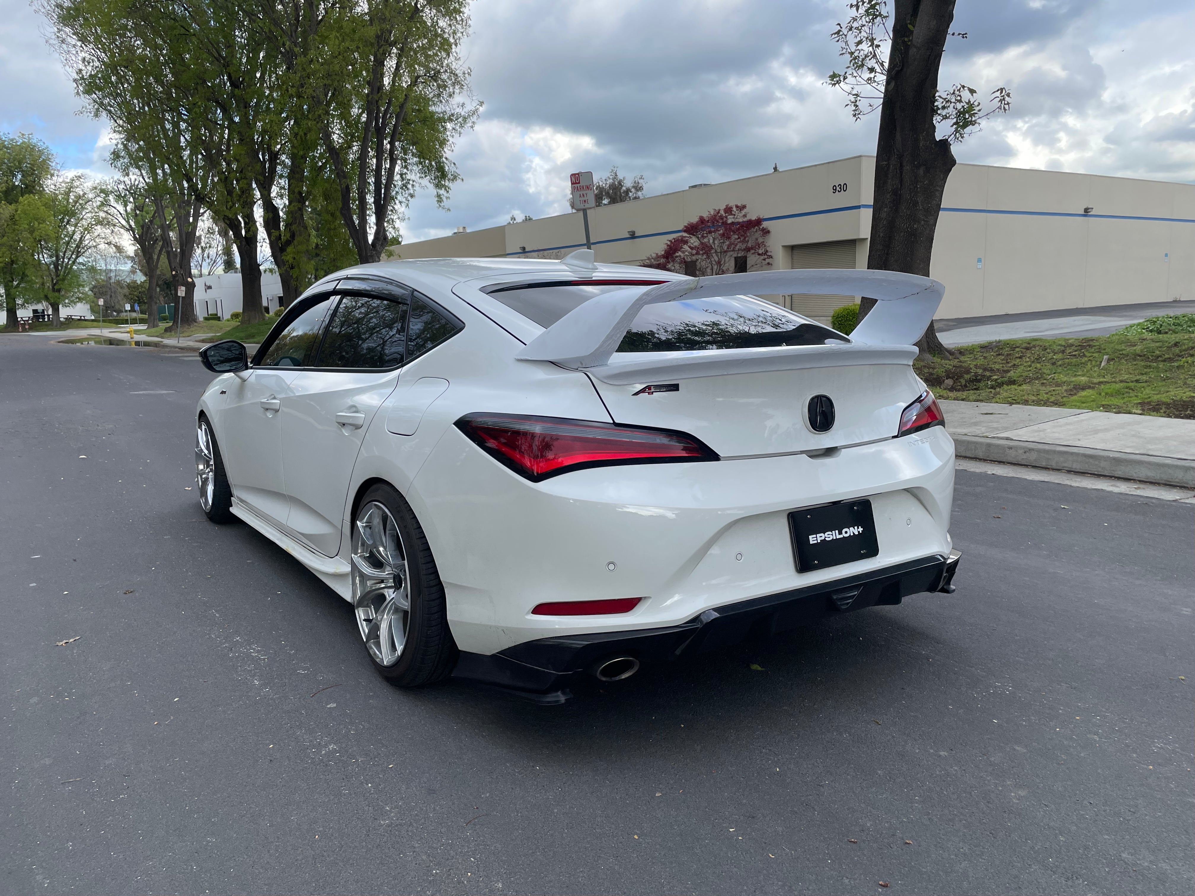 Rear three-quarter view of a white Acura Integra with rear spats fitted