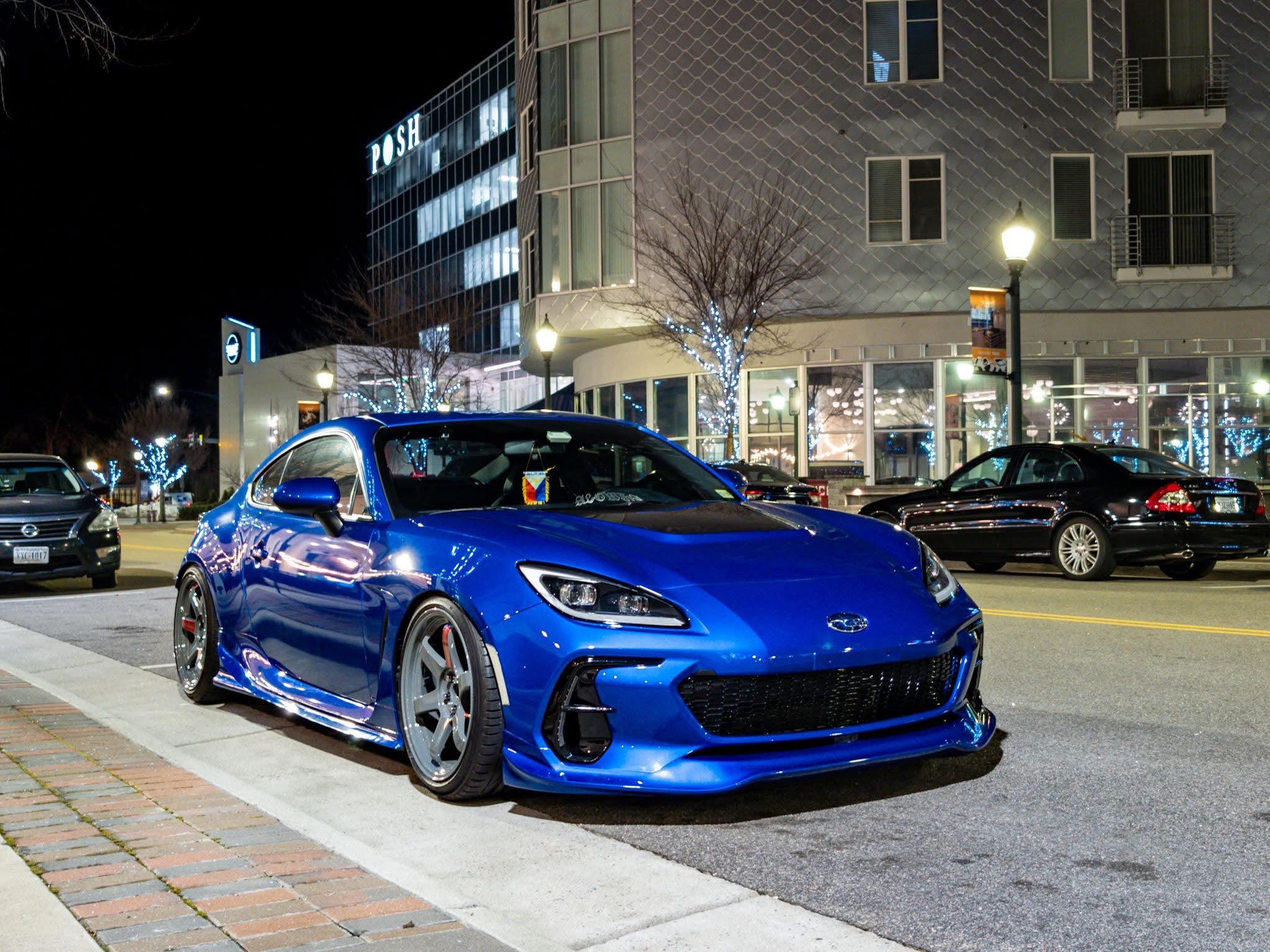 Blue Subaru BRZ ZN8 with front lip parked on a city street at night