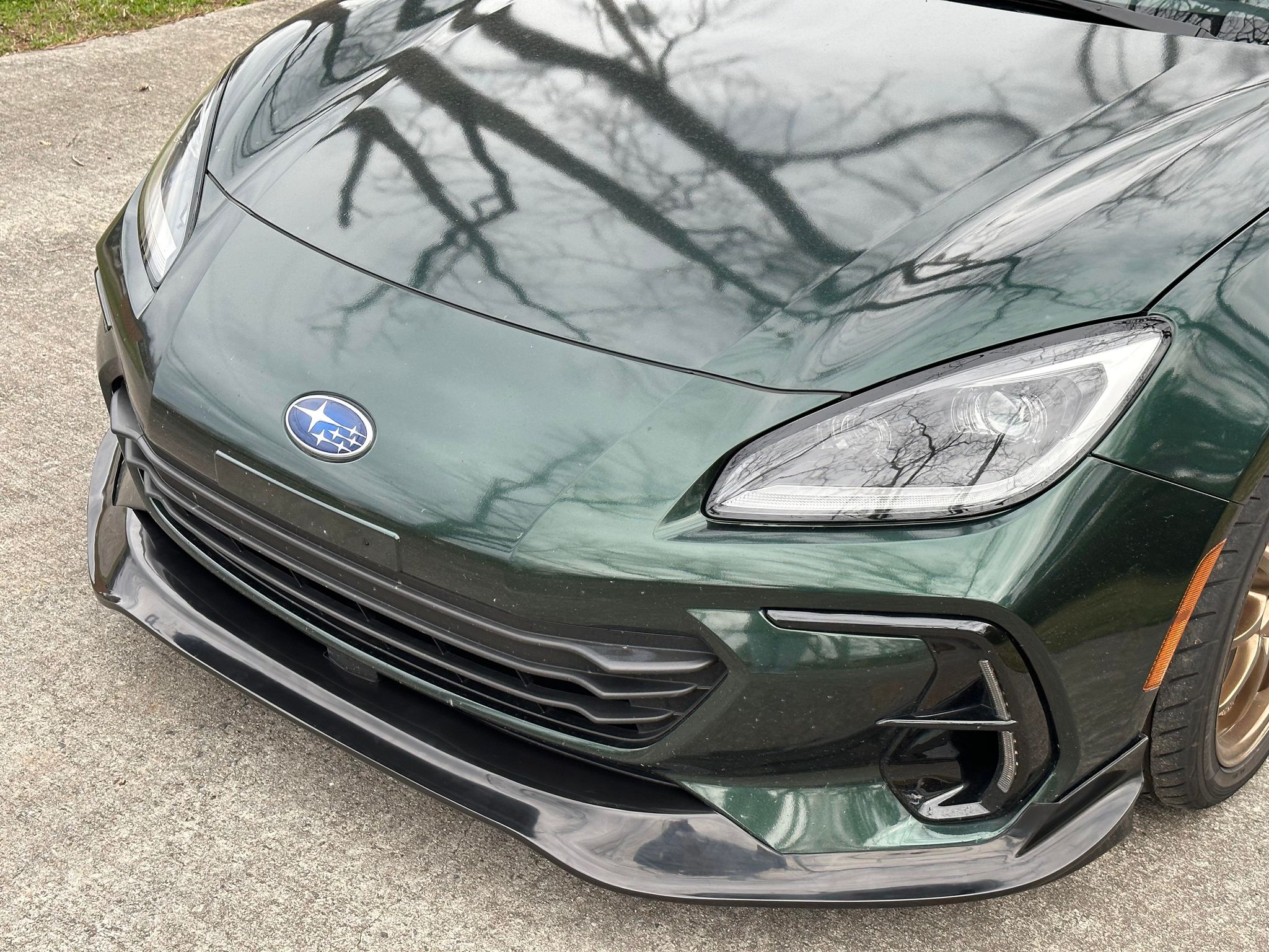 Close front view of a dark green Subaru BRZ ZN8 with the front lip fitted