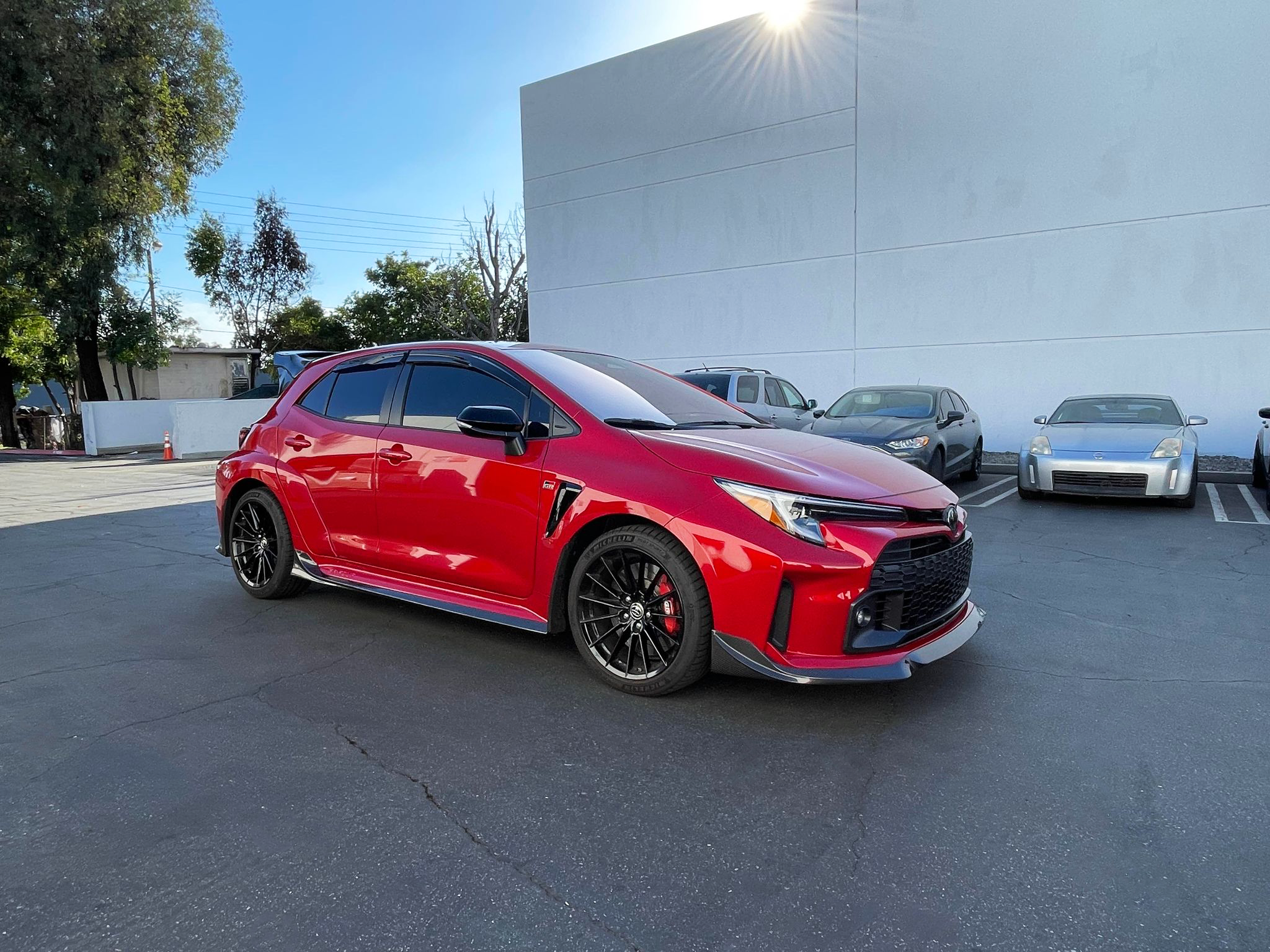 Front three-quarter view of a red GR Corolla with side skirts and front lip