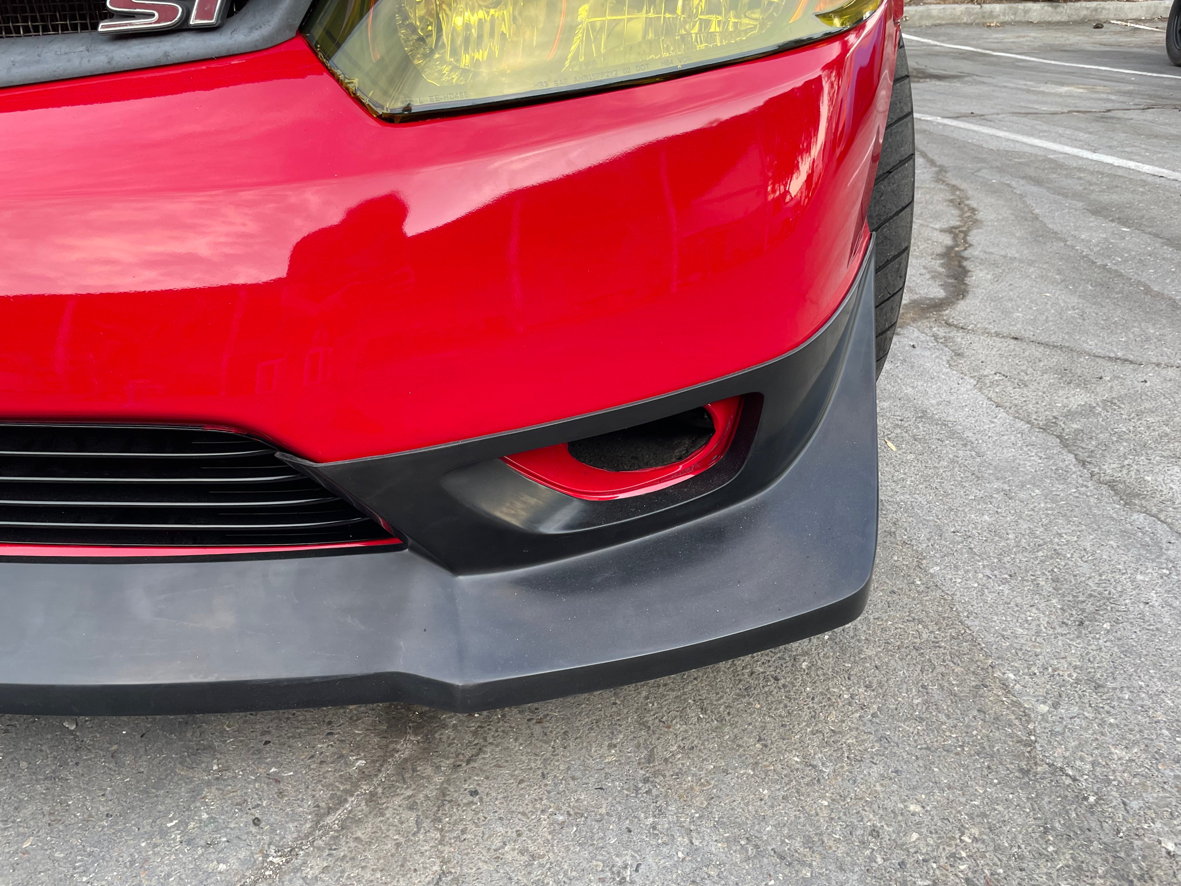 Close-up of the Epsilon+ front lip and lower splitter edge on a red Civic Coupe