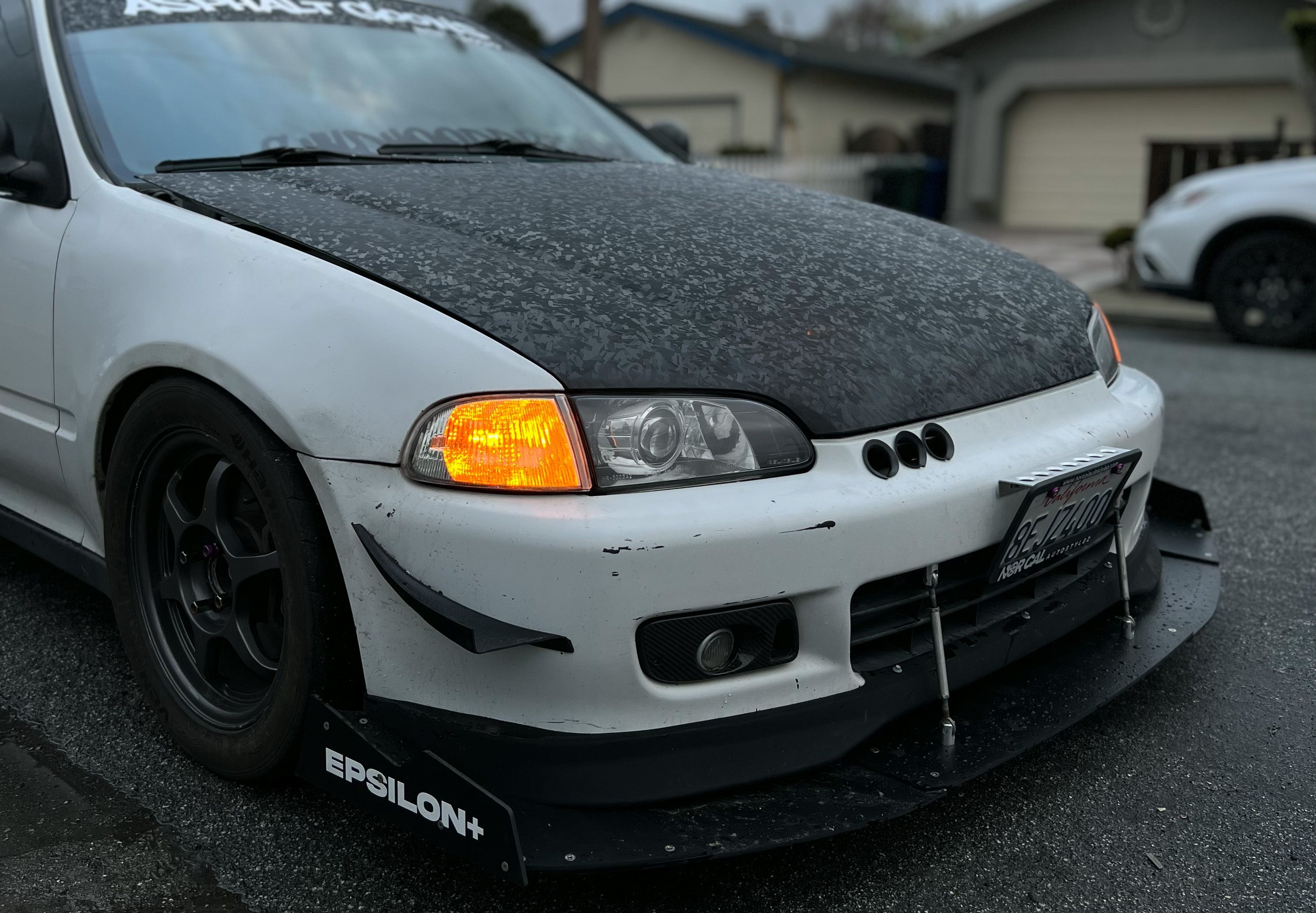 Front three-quarter view of a white Civic EG with front splitter, close-up of hammerhead extension