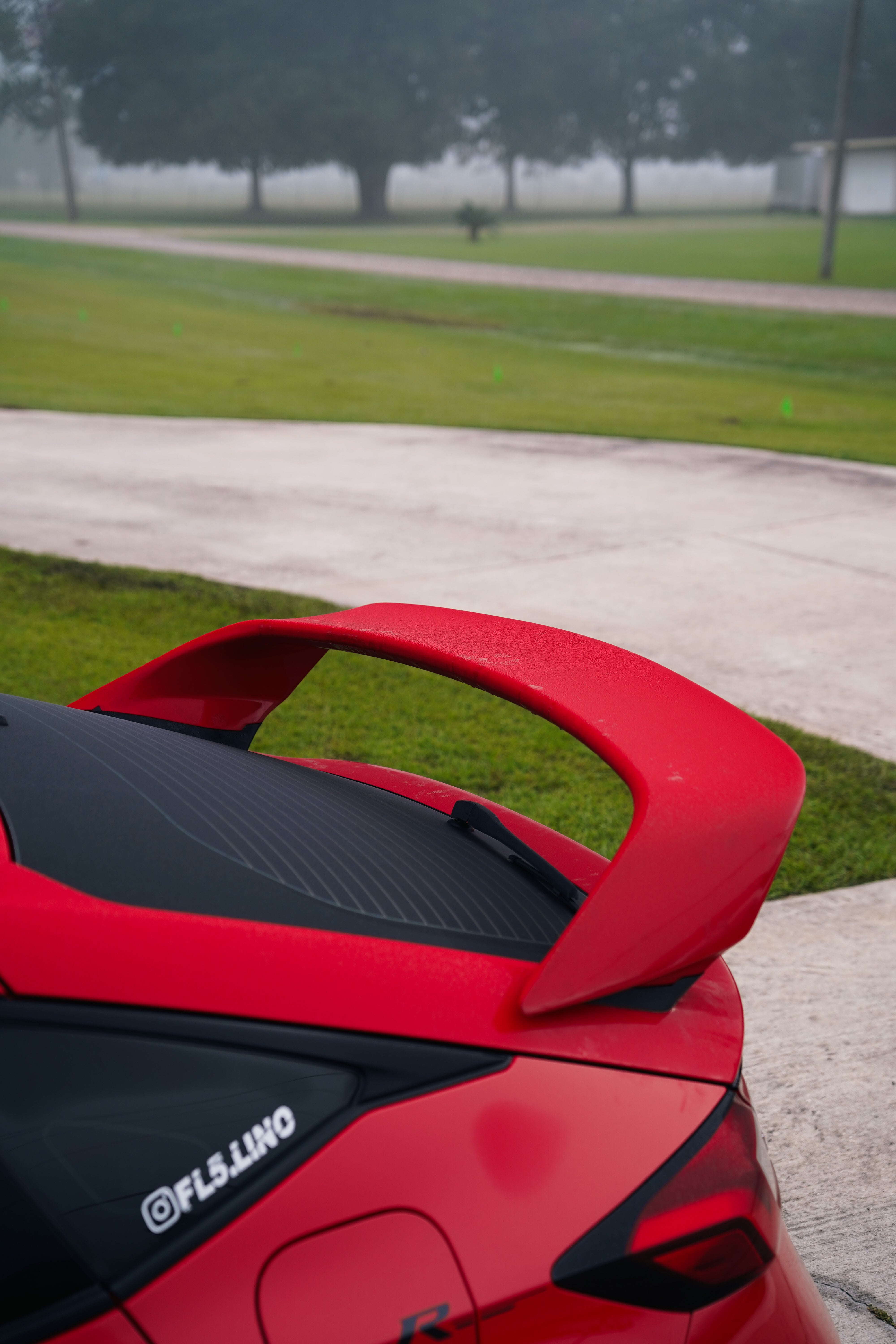 Close-up of the Epsilon+ Sport Wing blade on a red Honda Civic FL5