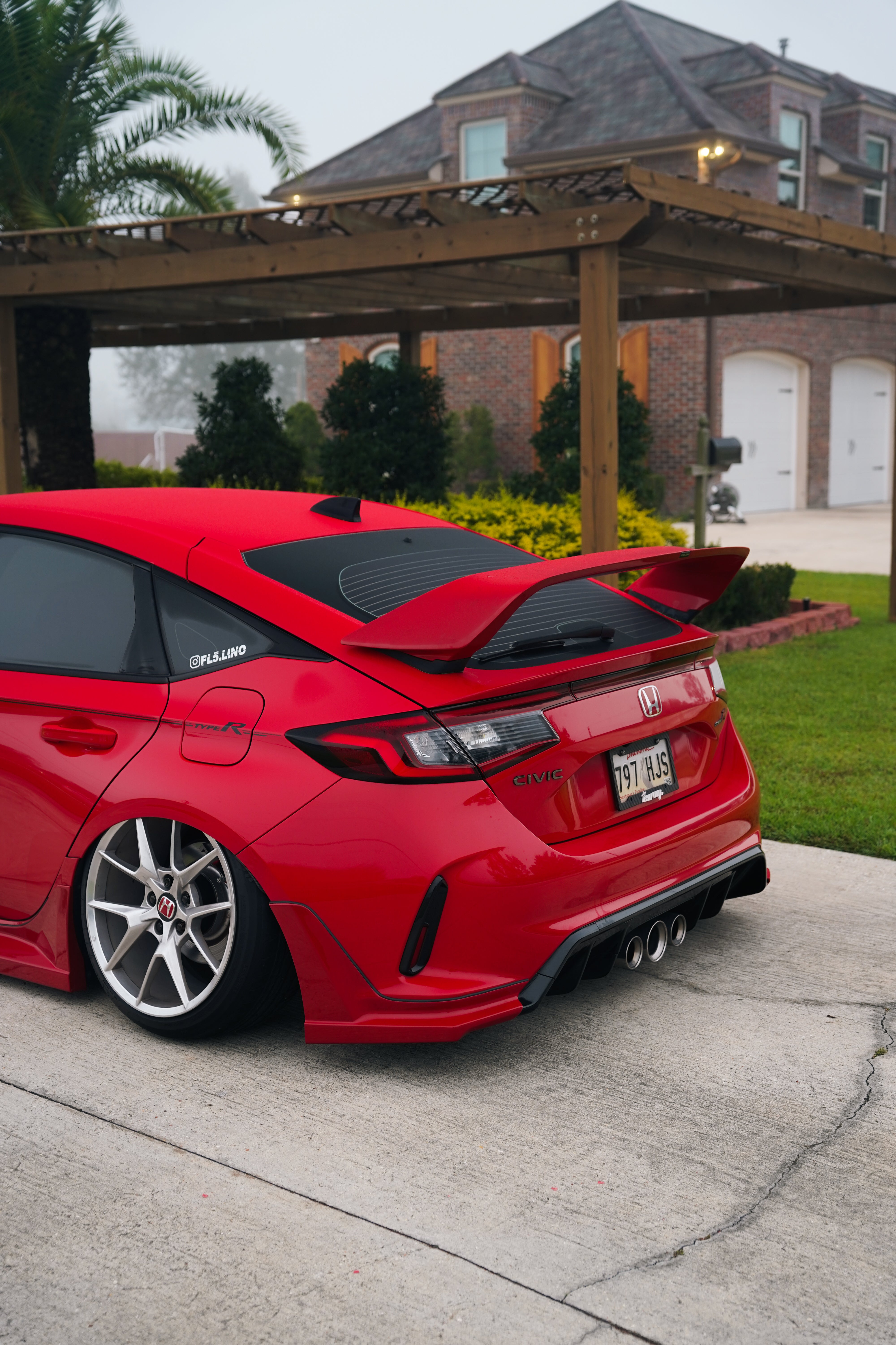 Red Honda Civic Type R FL5 with Sport Wing parked beside a pergola