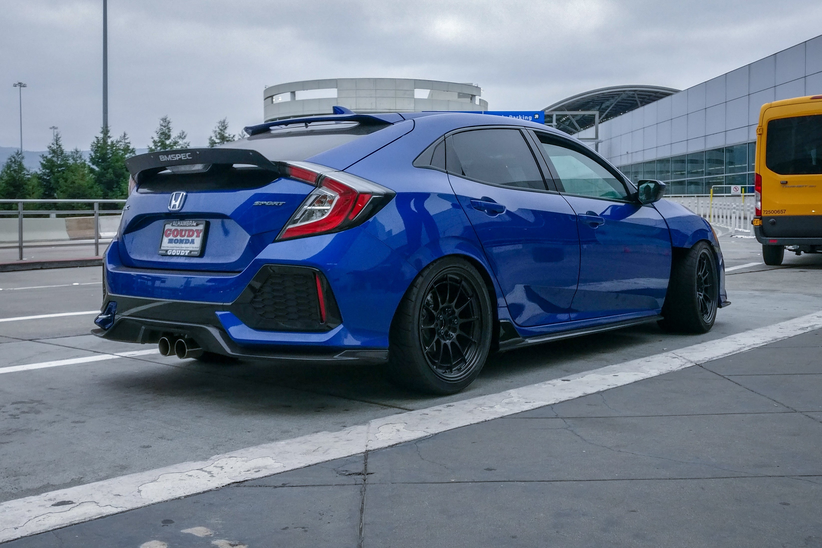 Rear three-quarter view of a blue Civic Hatchback FK7 with spoiler extension