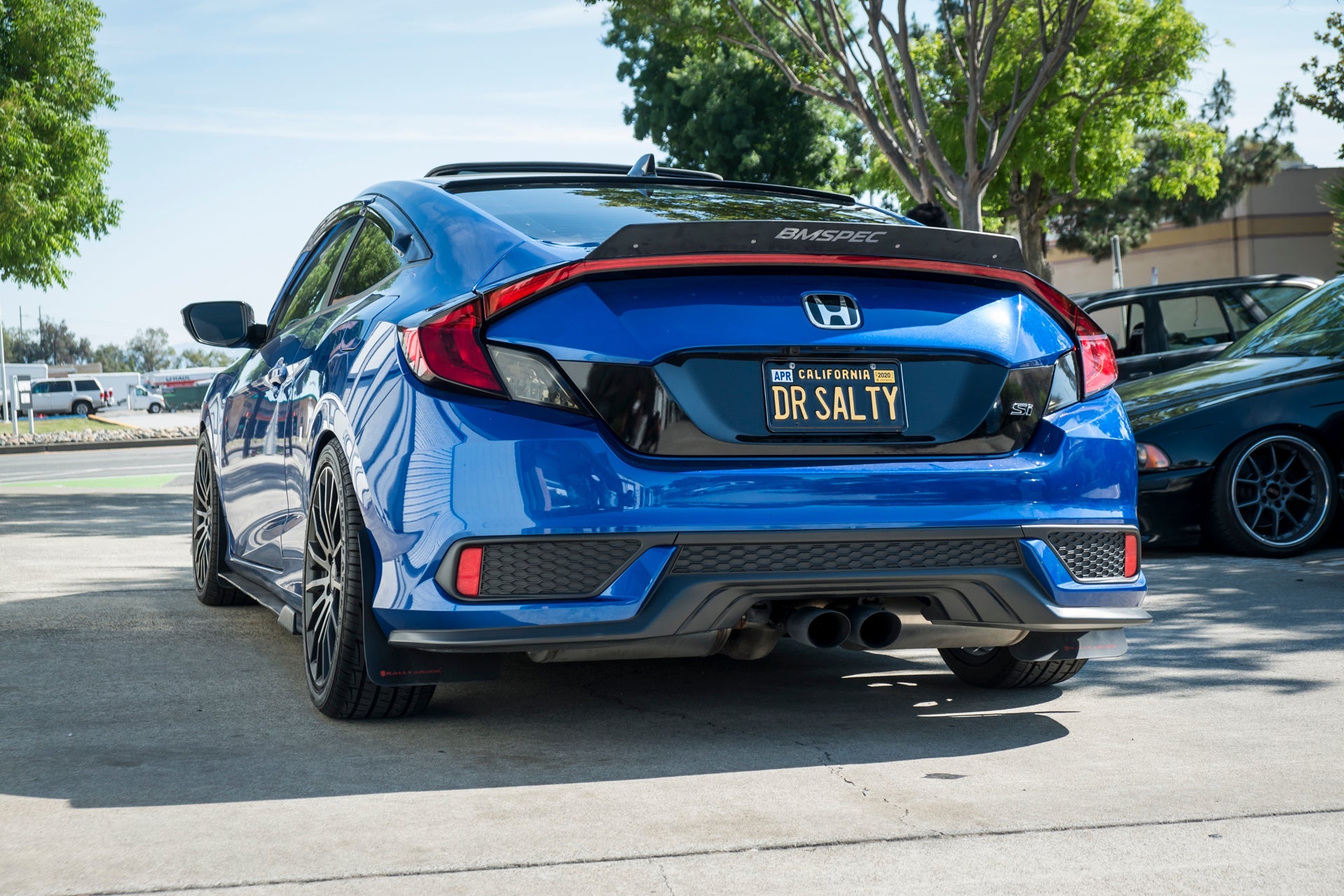Rear view of a blue Civic non-Si Coupe showing the spoiler extension and taillights