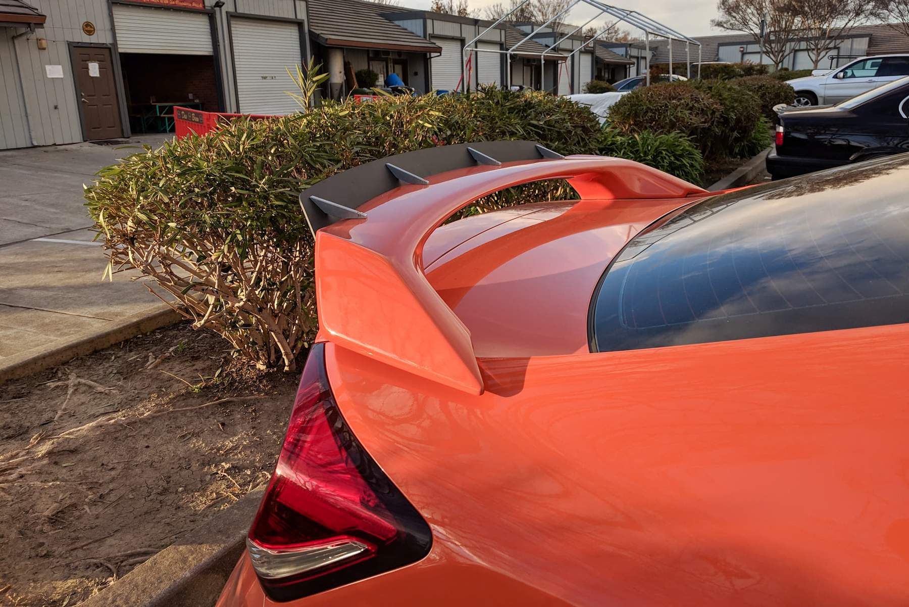 Close-up of the spoiler extension mounted on an orange Civic Si Coupe FG4 Kouki