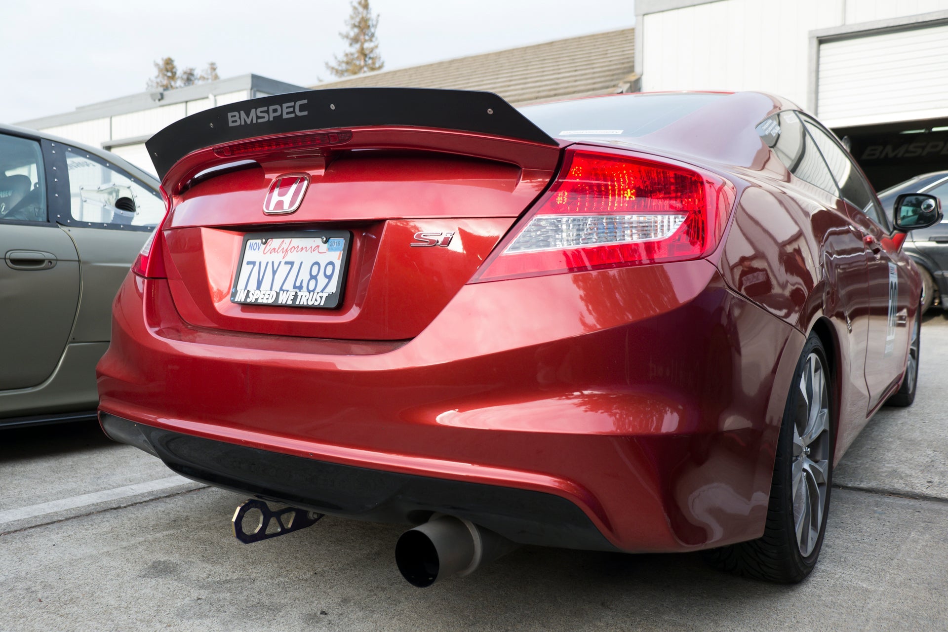Rear three-quarter view of a red Civic Si Coupe Zenki with spoiler extension and BMSpec decal