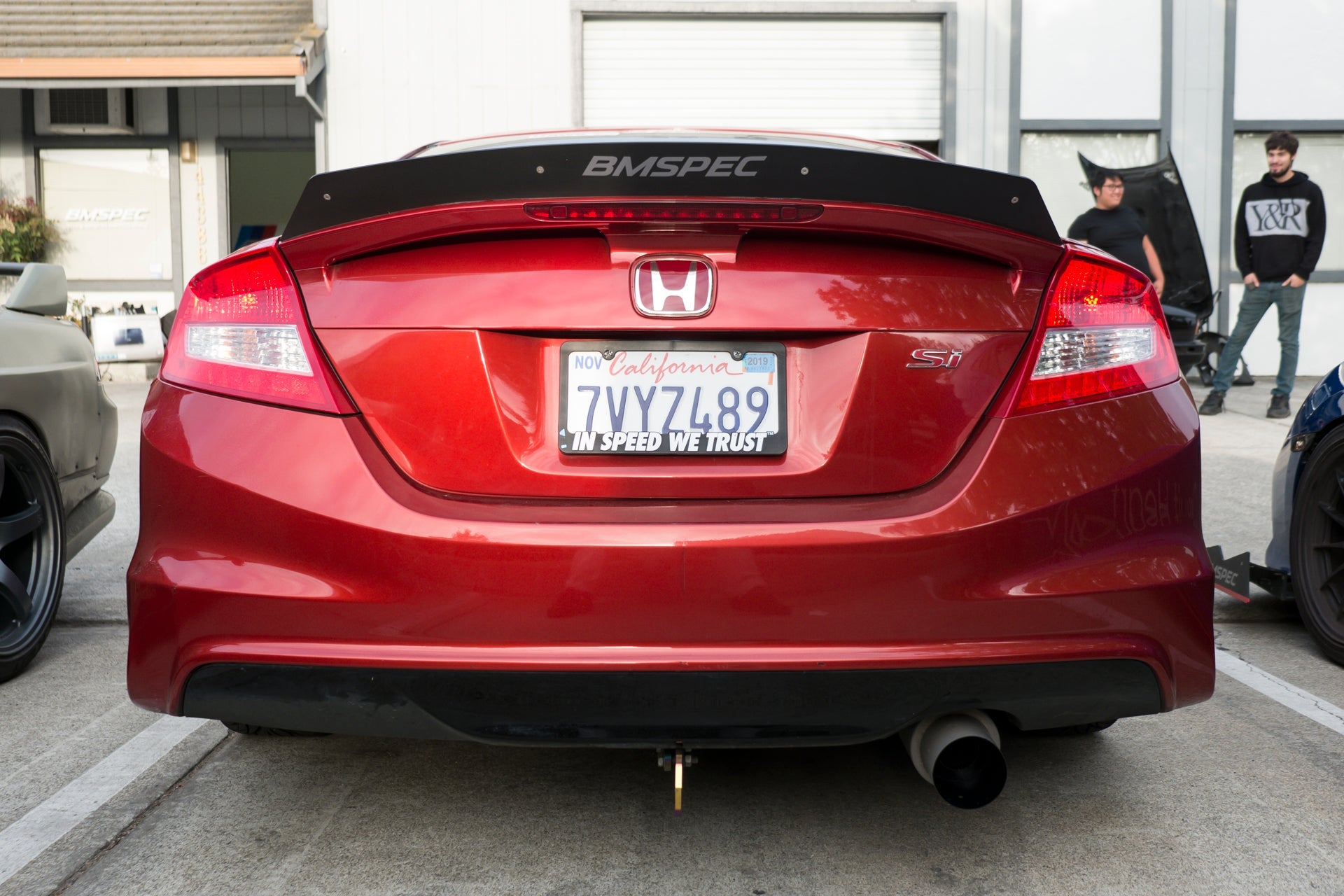 Rear view of a red Civic Si Coupe Zenki showing the spoiler extension and taillights