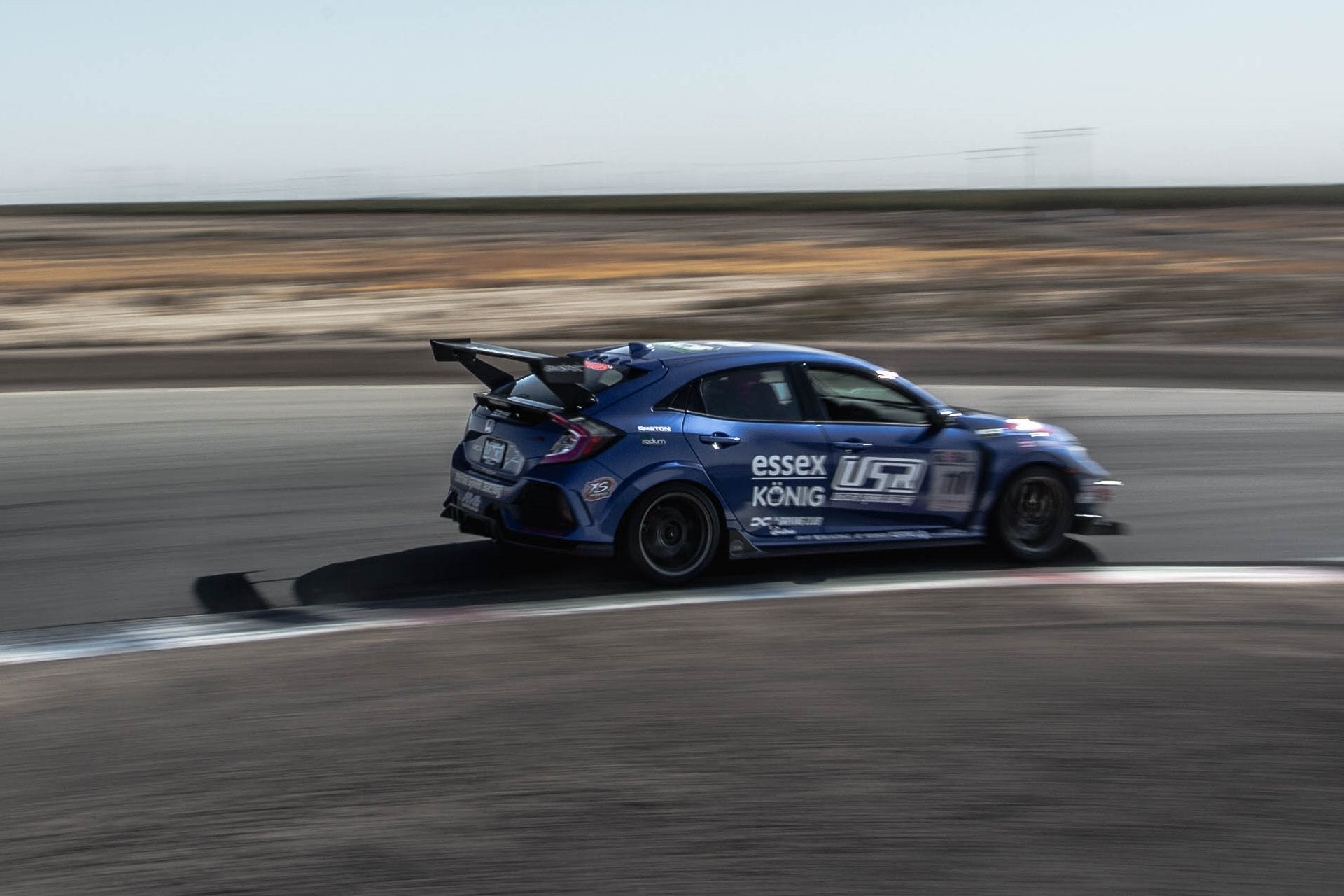 Civic Type R motorsport racer with Essex/König livery cornering on track with Epsilon+ GT wing