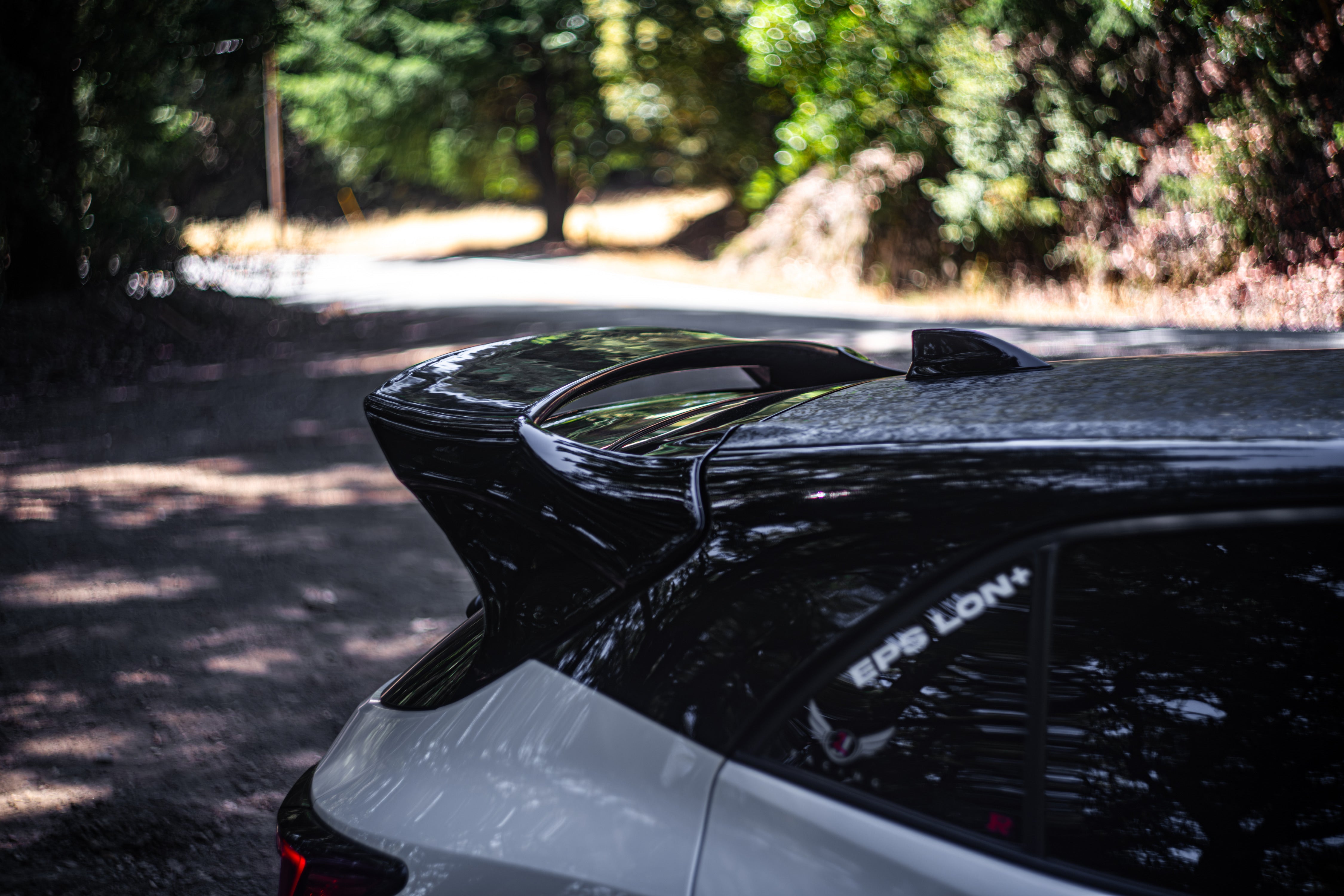 Close-up of the WRC Wing V3 mount and Epsilon+ branding on a white Corolla Hatchback