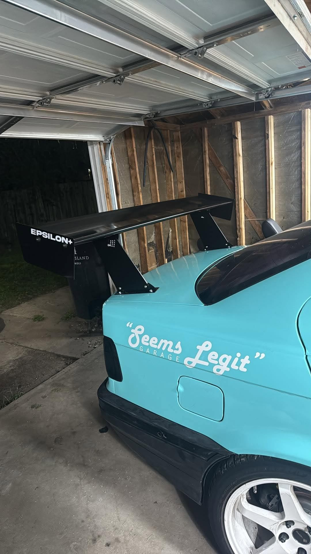 Close-up of the Epsilon+ TC Wing swan mount on a BMW E36 trunk