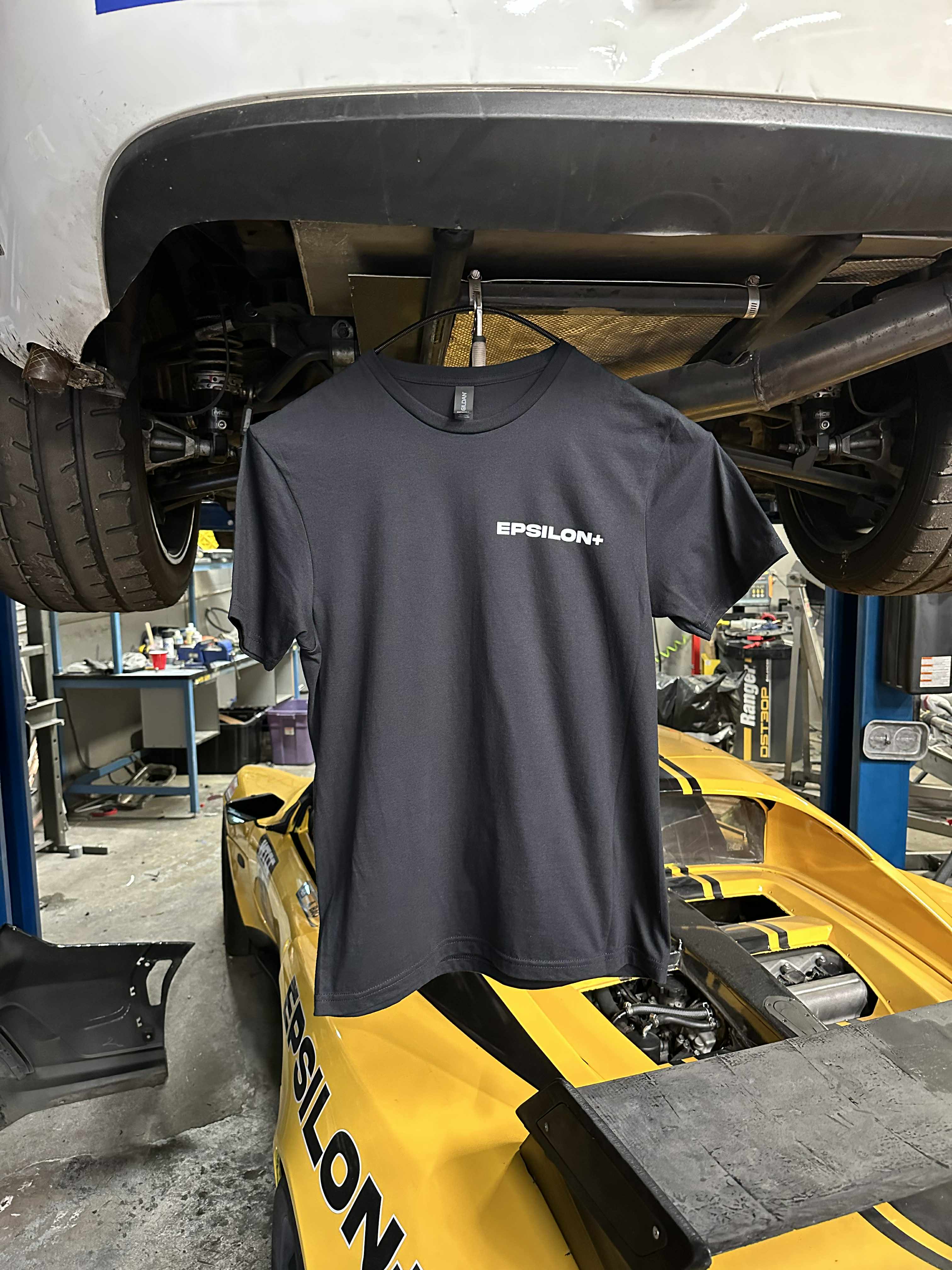 Grey Epsilon+ t-shirt with small chest logo, hung in the workshop