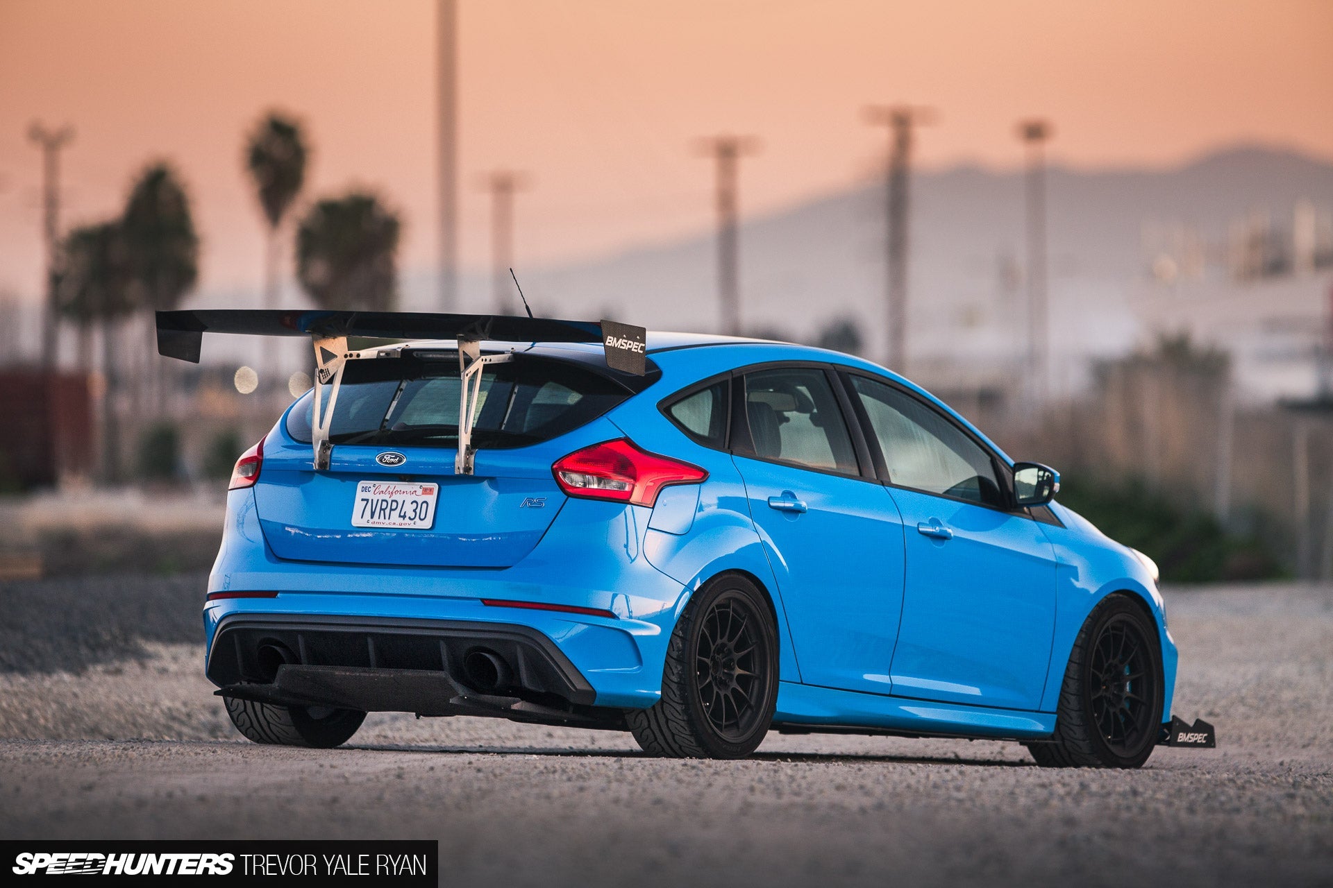 Side profile of a blue Focus RS with GT wing at sunset