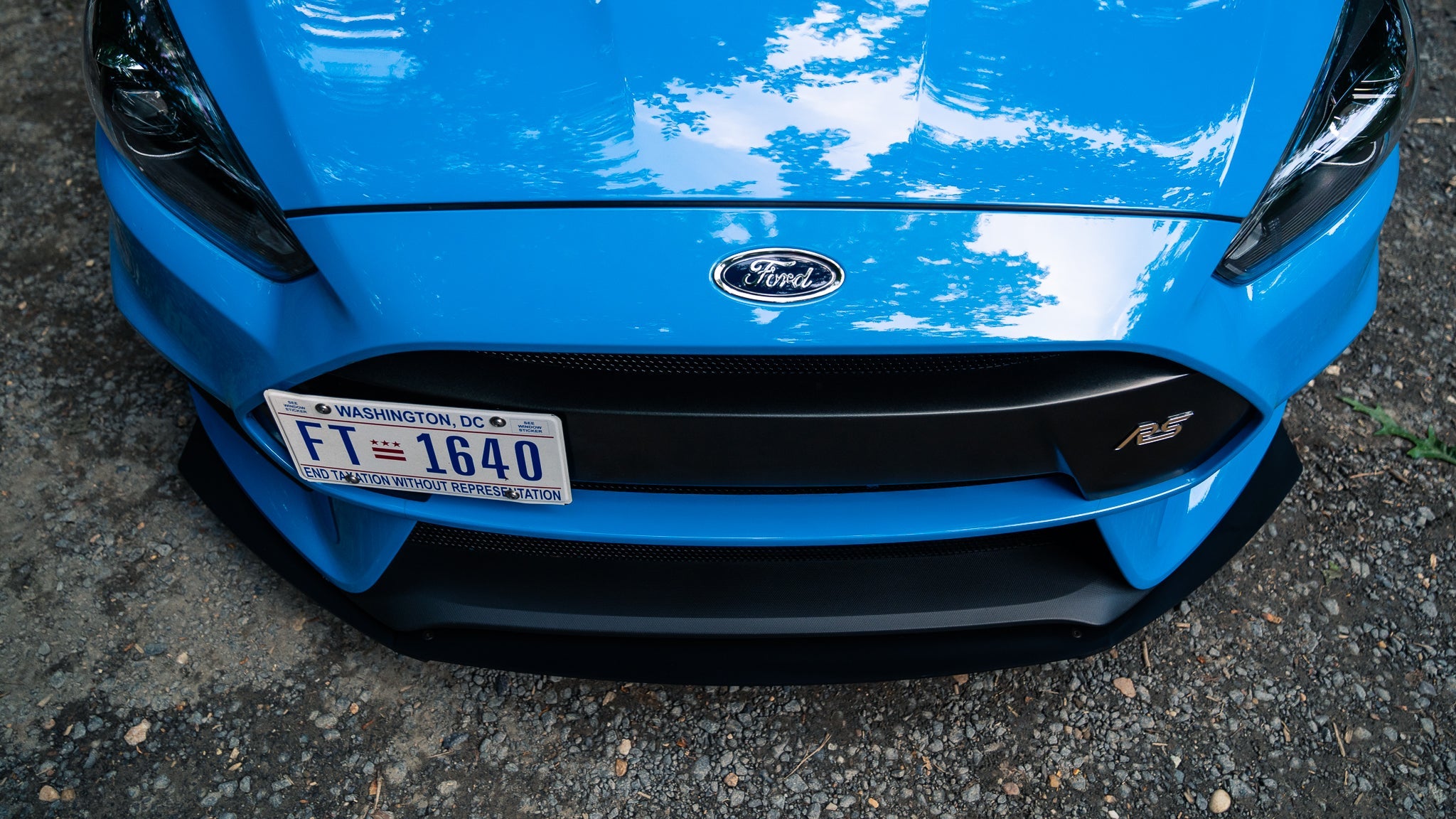 Close-up front view of the Epsilon+ front lip on a blue Focus RS bumper