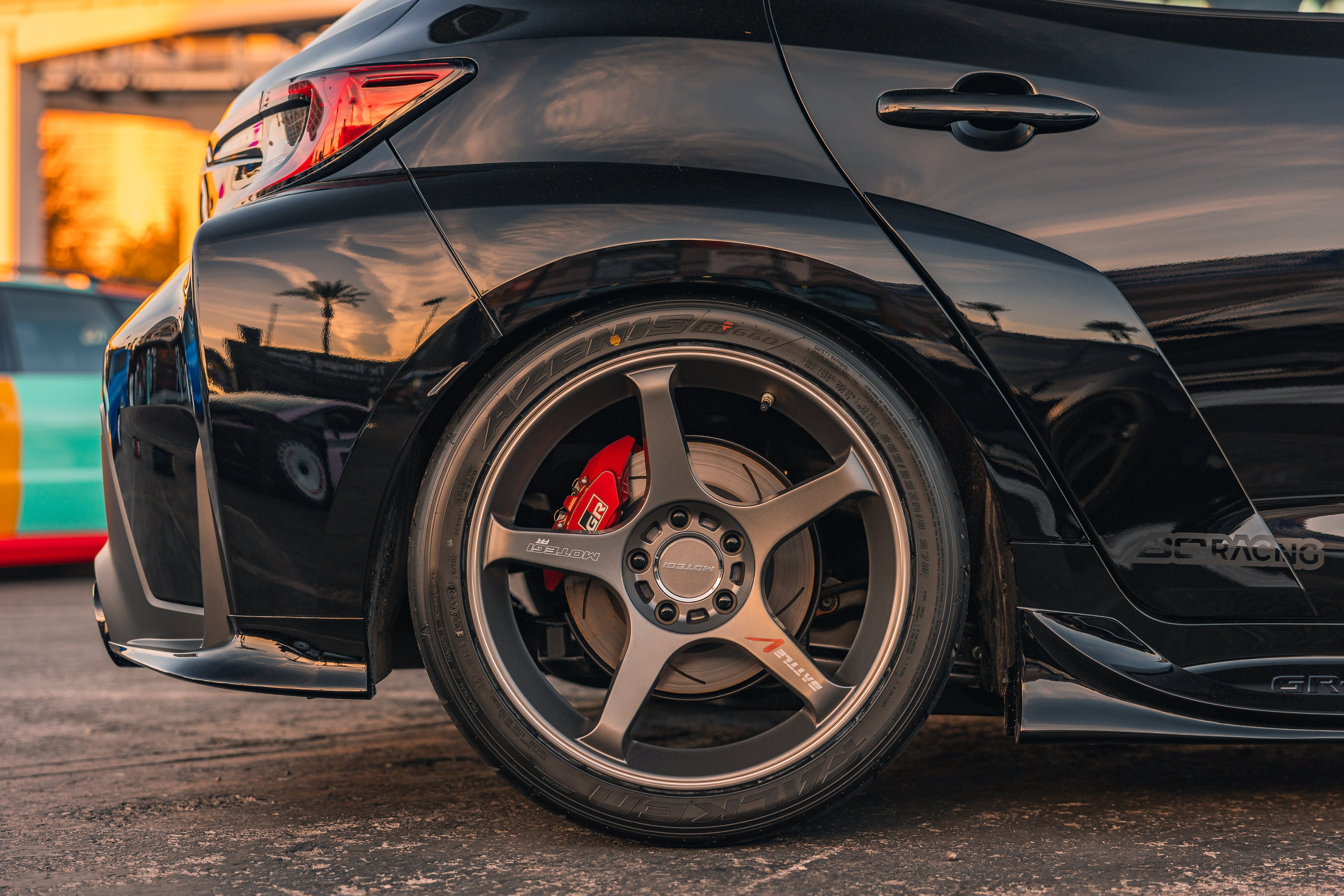 Close-up of a black GR Corolla rear fender showing the rear spat and bronze wheel