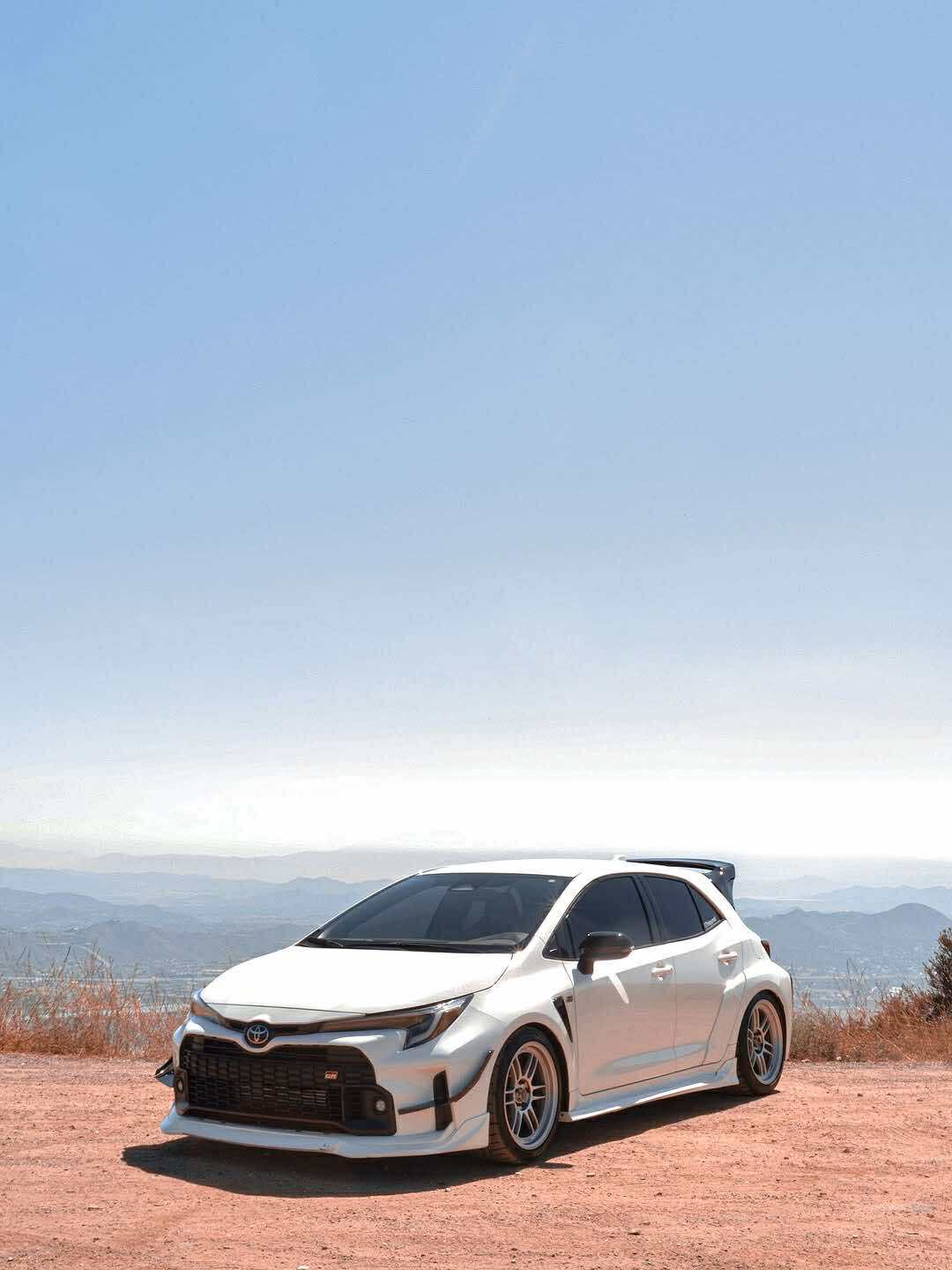 Close-up side view of a white GR Corolla with side skirts