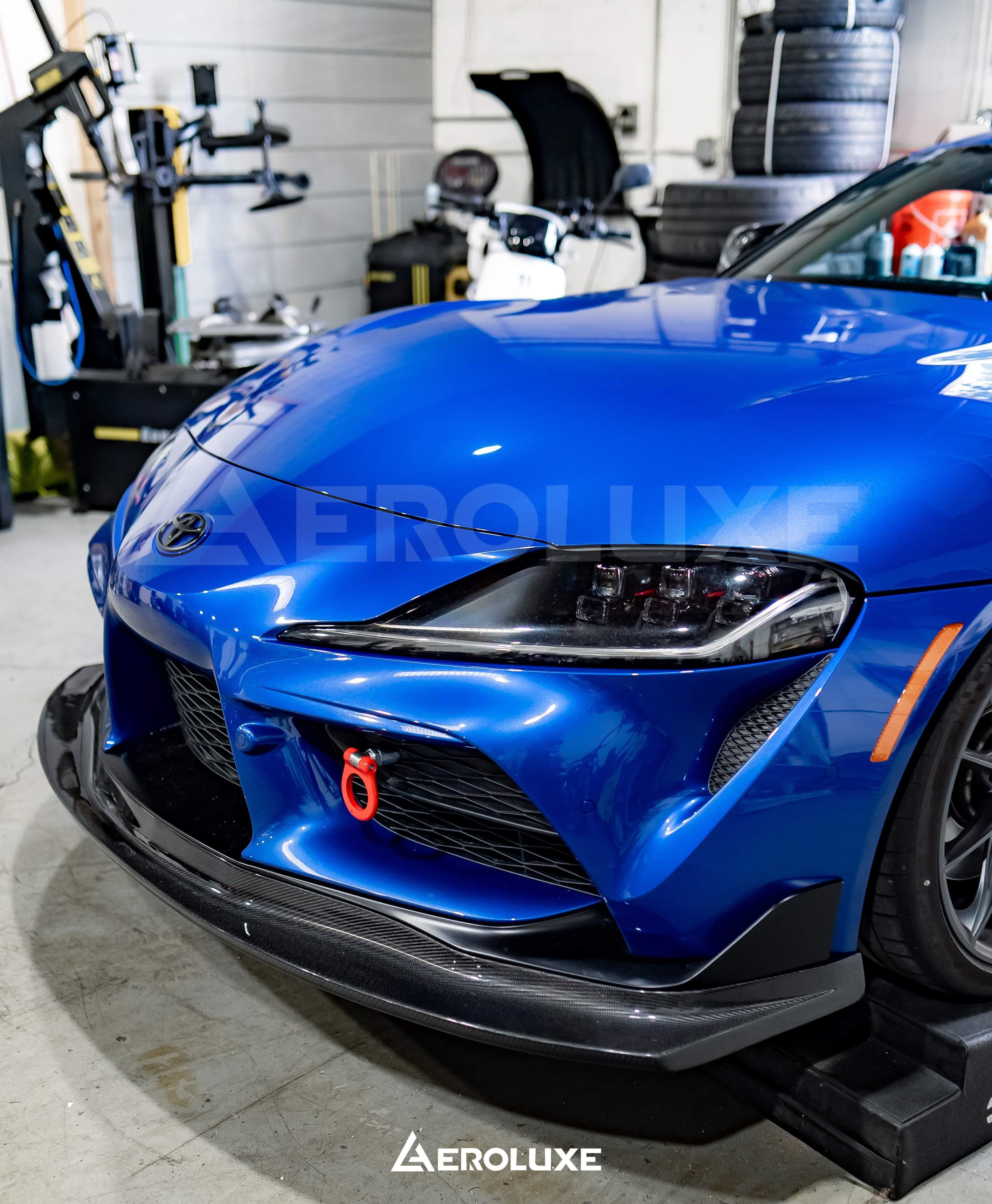 Blue Toyota GR Supra with GT4-spec front lip fitted in the workshop