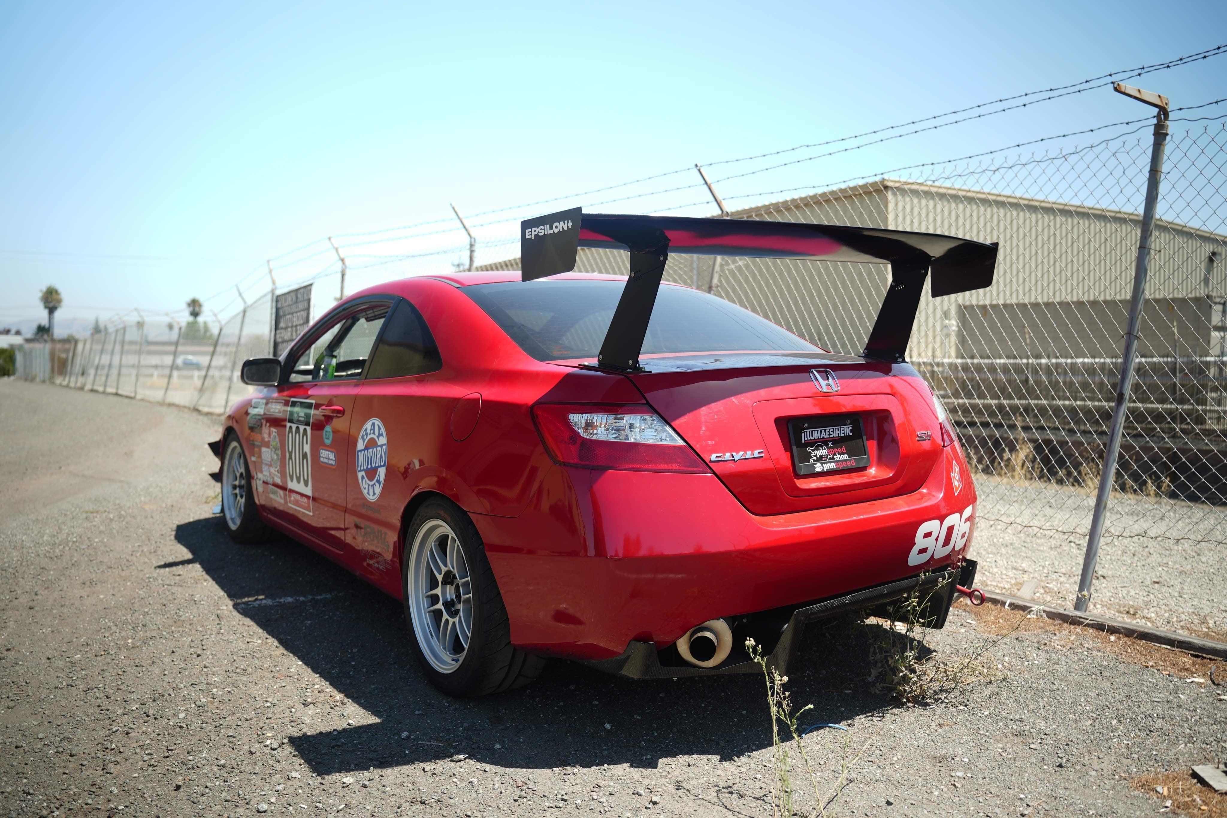 Rear three-quarter view of a red Civic Coupe FG2 race car with GT wing
