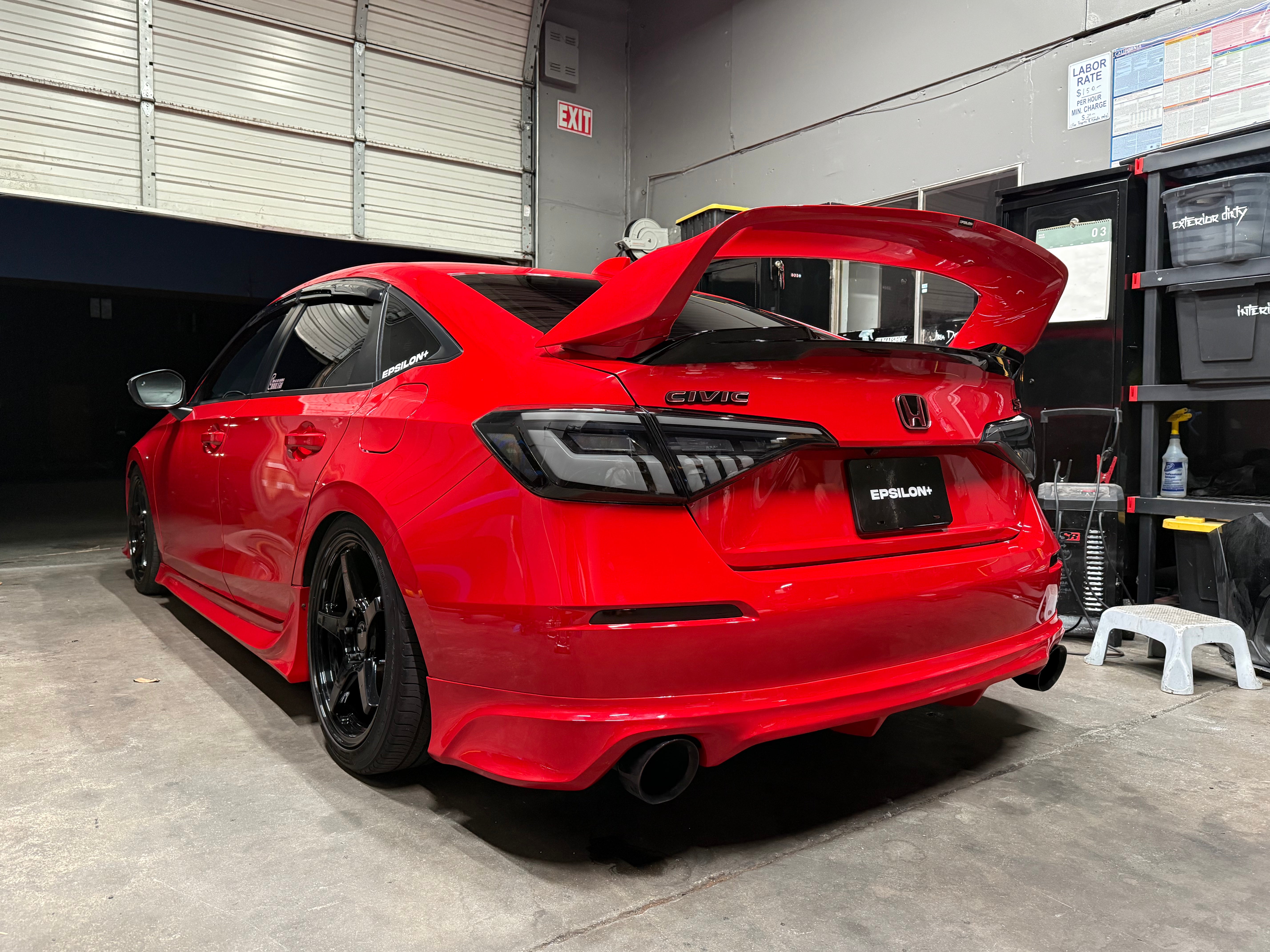 Rear three-quarter view of a red Honda Civic Sedan with the Epsilon+ rear lip