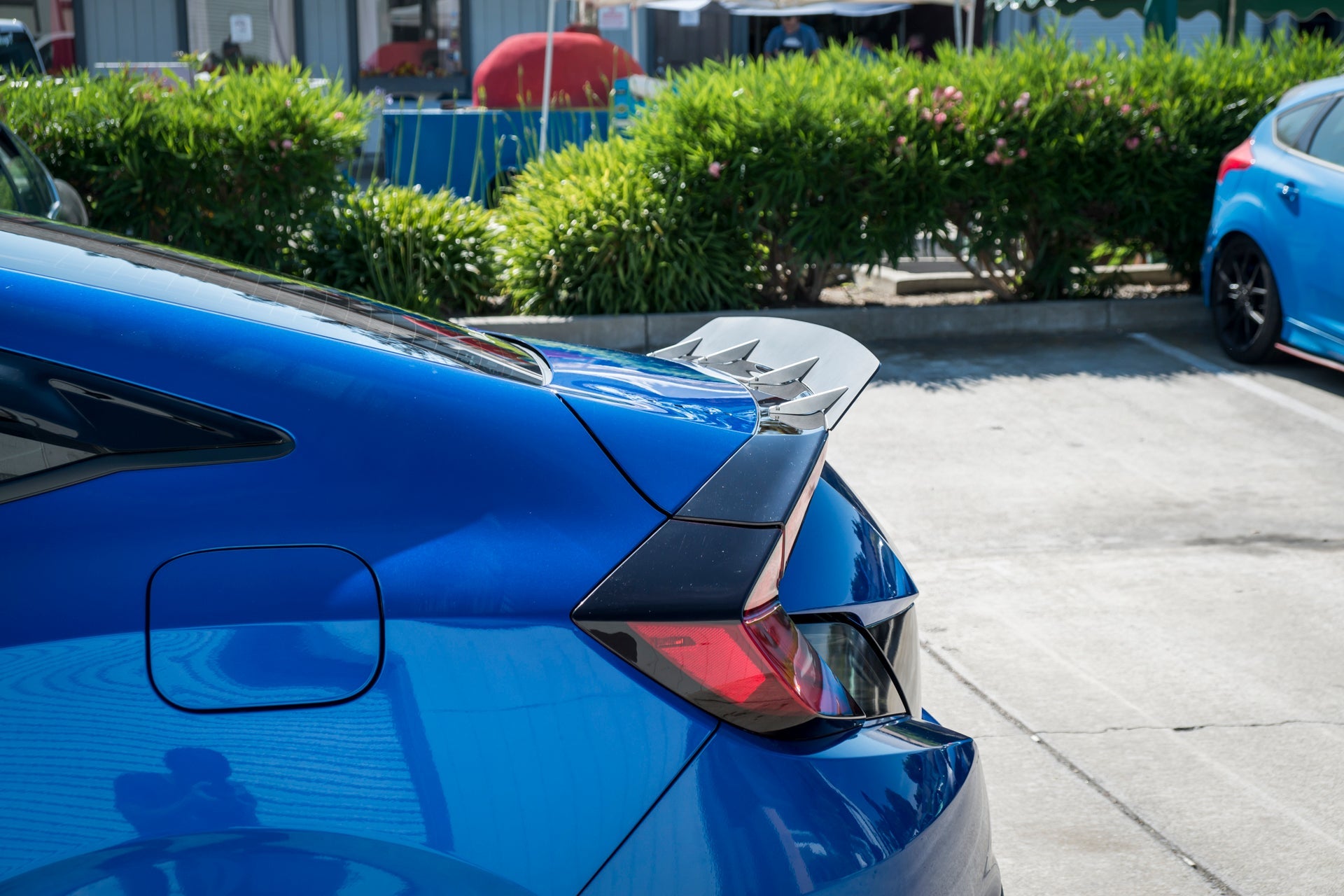 Close-up of the spoiler extension on a blue Civic non-Si Coupe trunk lid