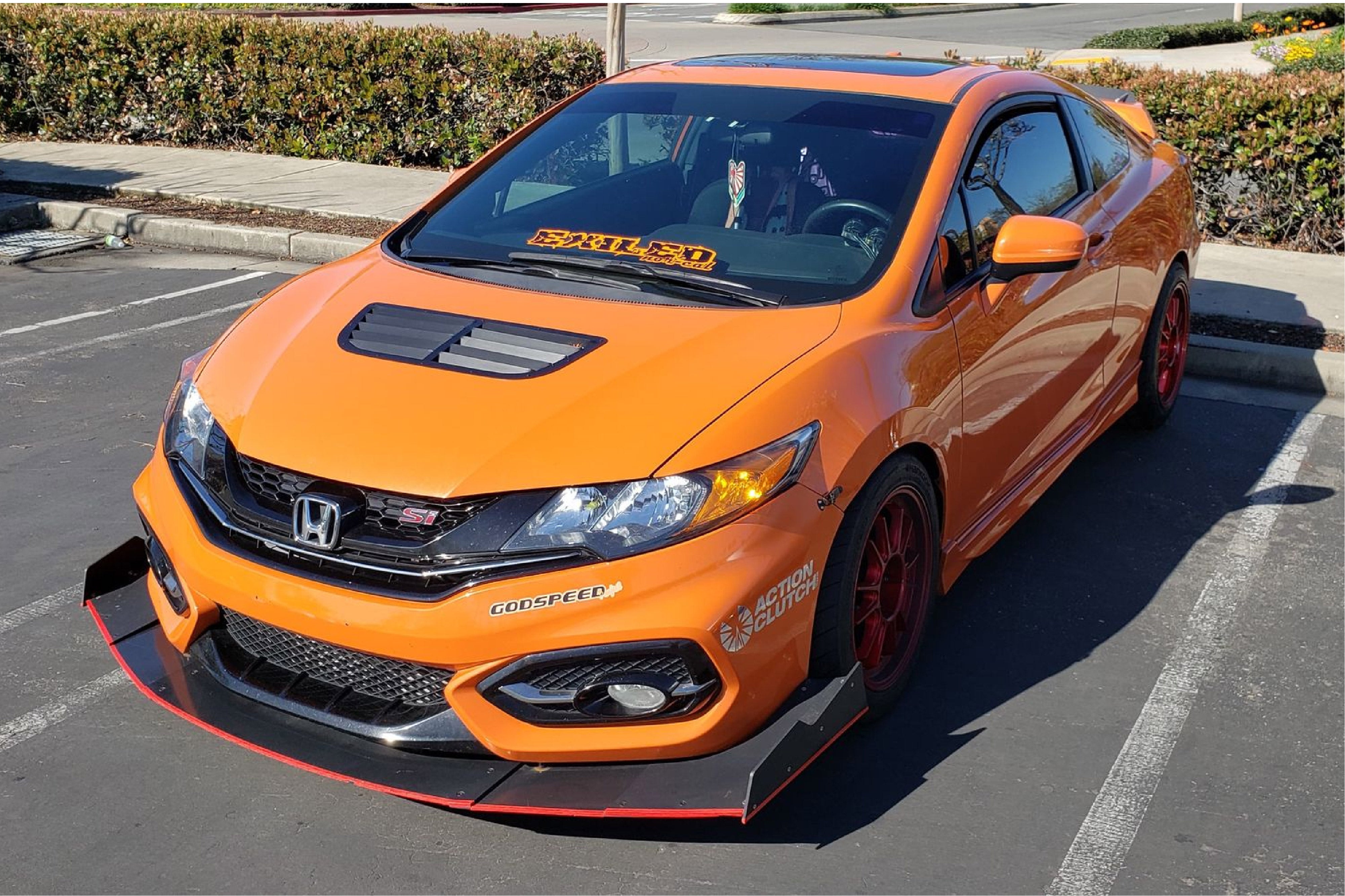 Front three-quarter view of an orange Civic Si Coupe FG4 with front splitter in a parking lot