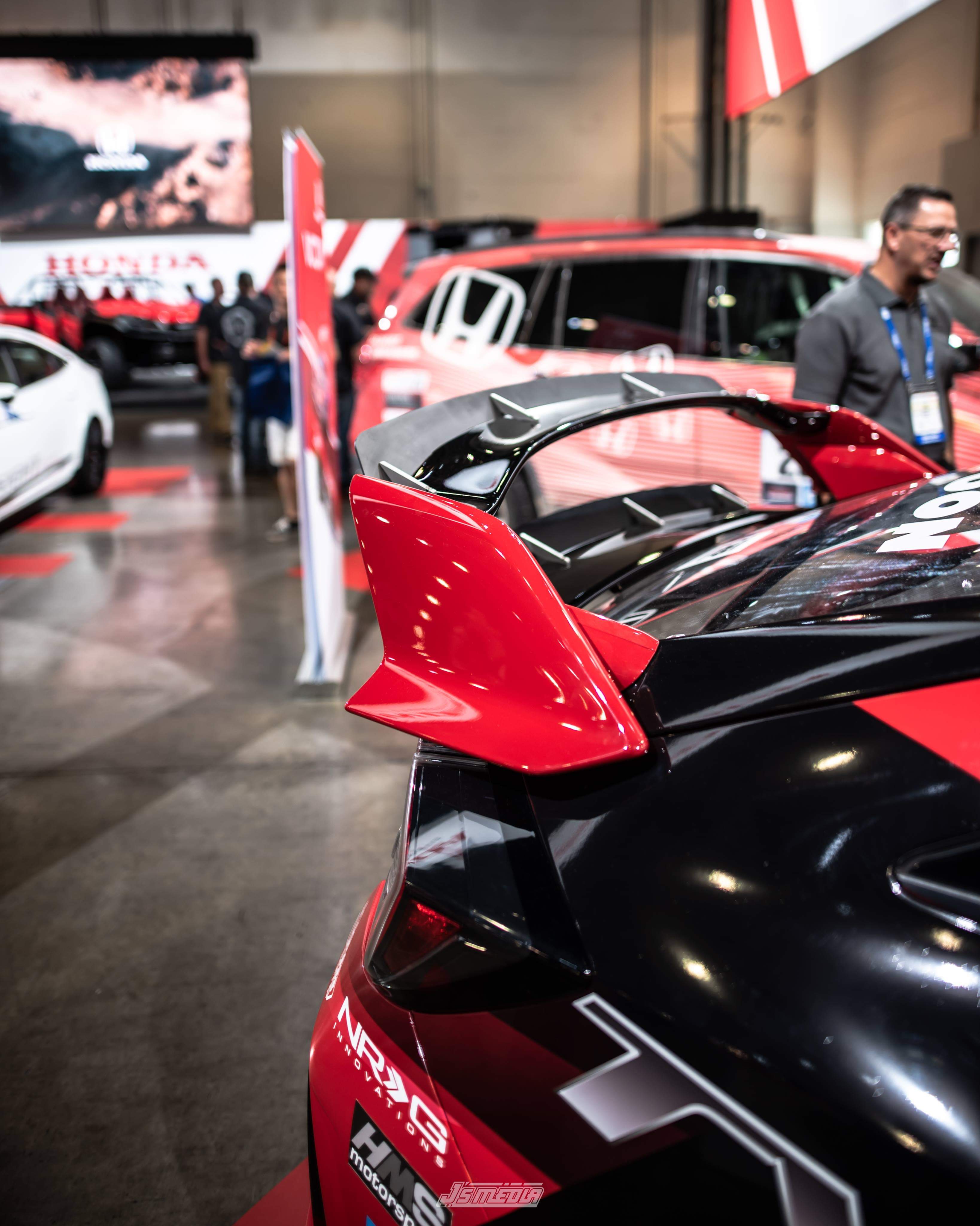 Red and black Civic Type R with double spoiler extension on display at a car show