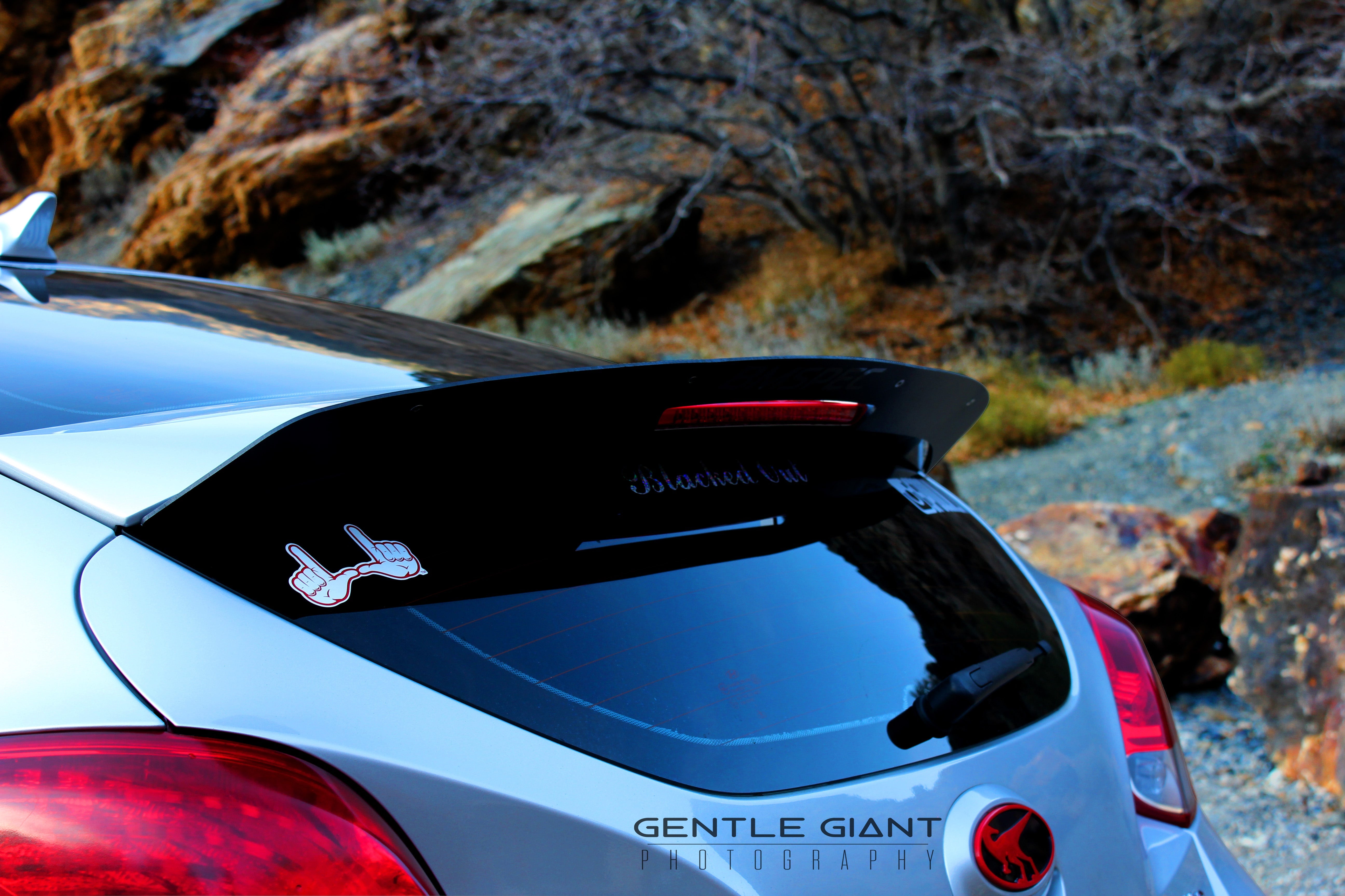 Rear three-quarter view of a white Veloster Turbo with Epsilon+ spoiler extension