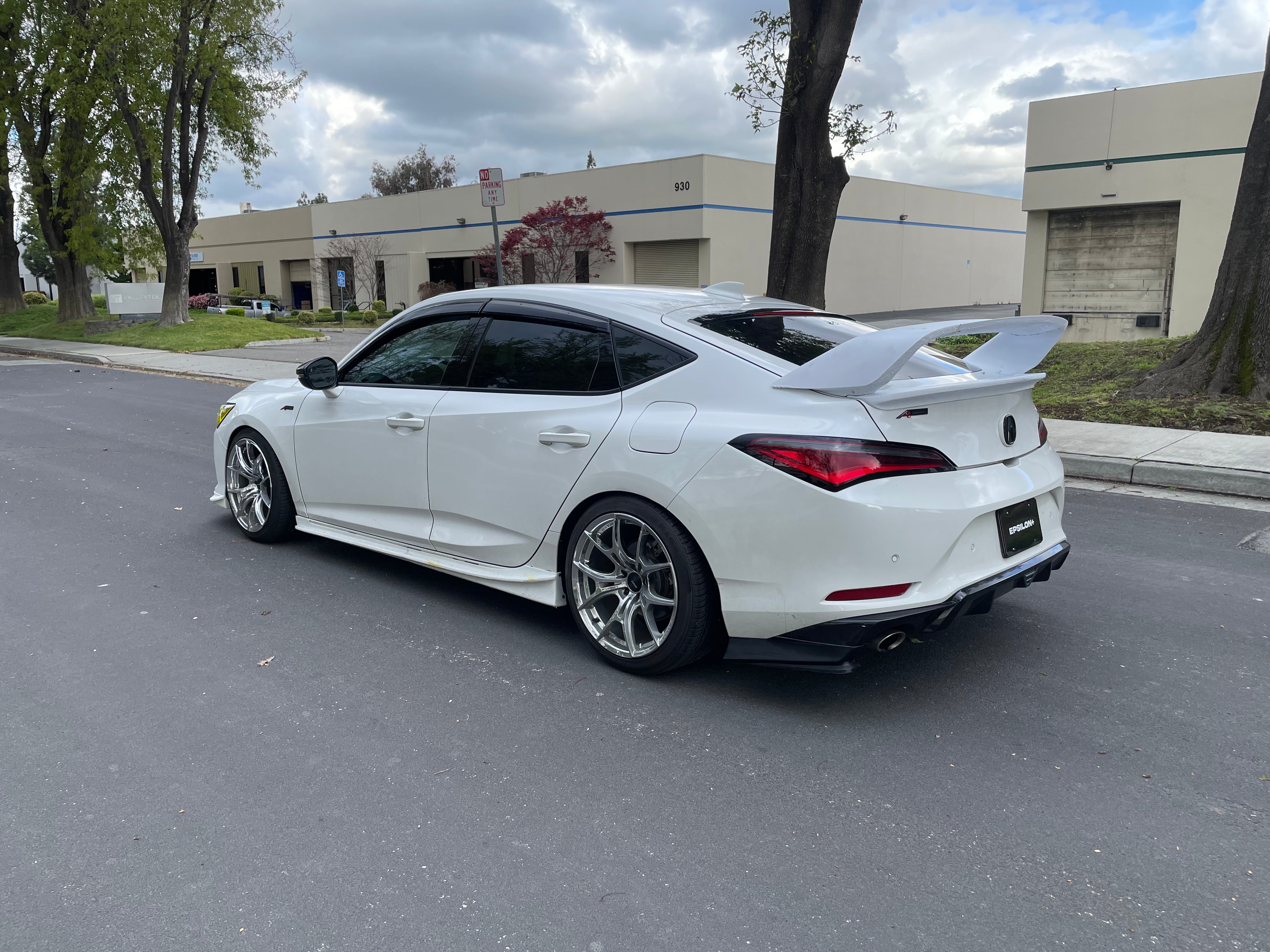 White Acura Integra with rear spats and trunk lip on a residential street