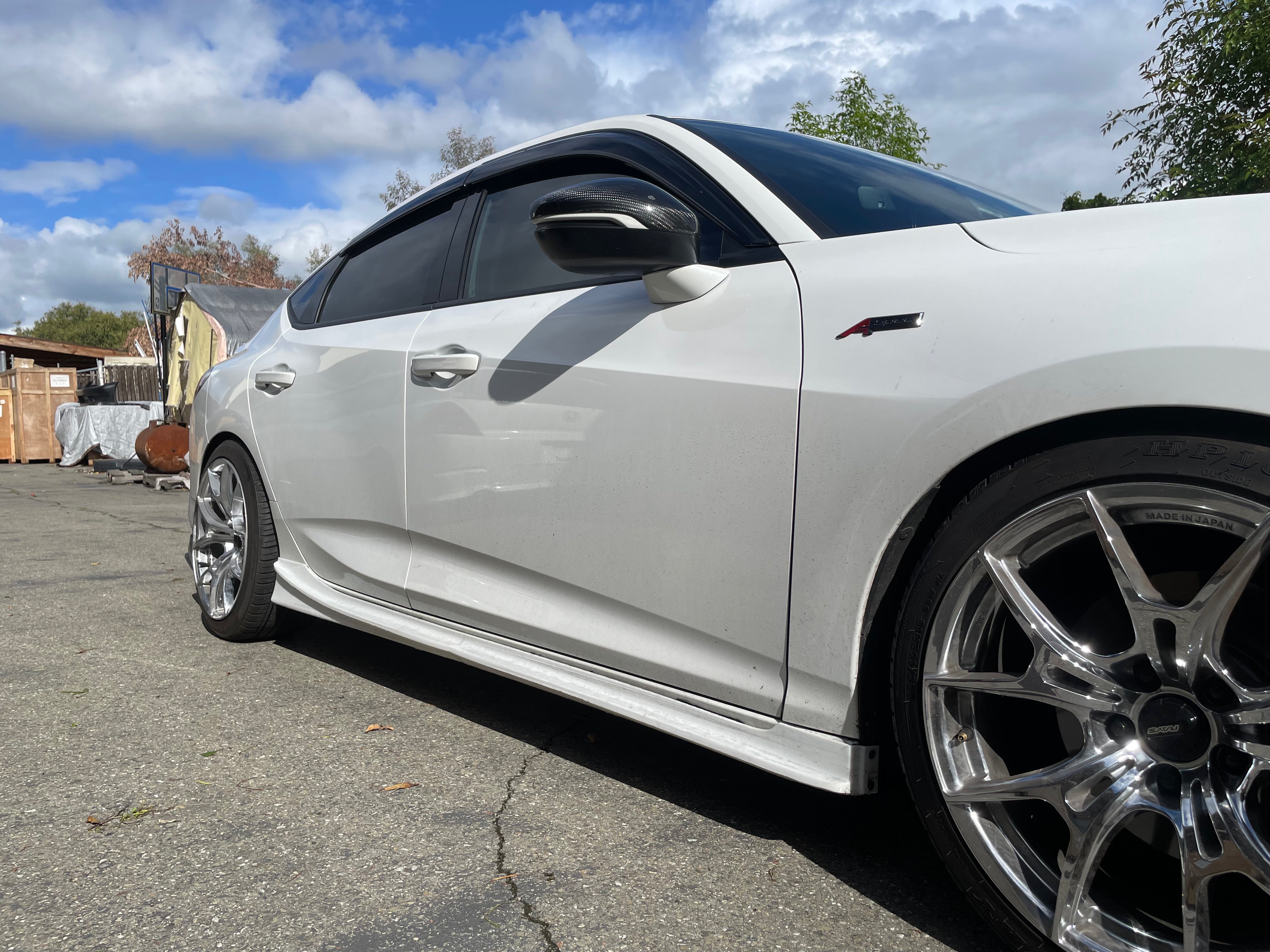 Close side view of the side skirt and wheel on a white Acura Integra