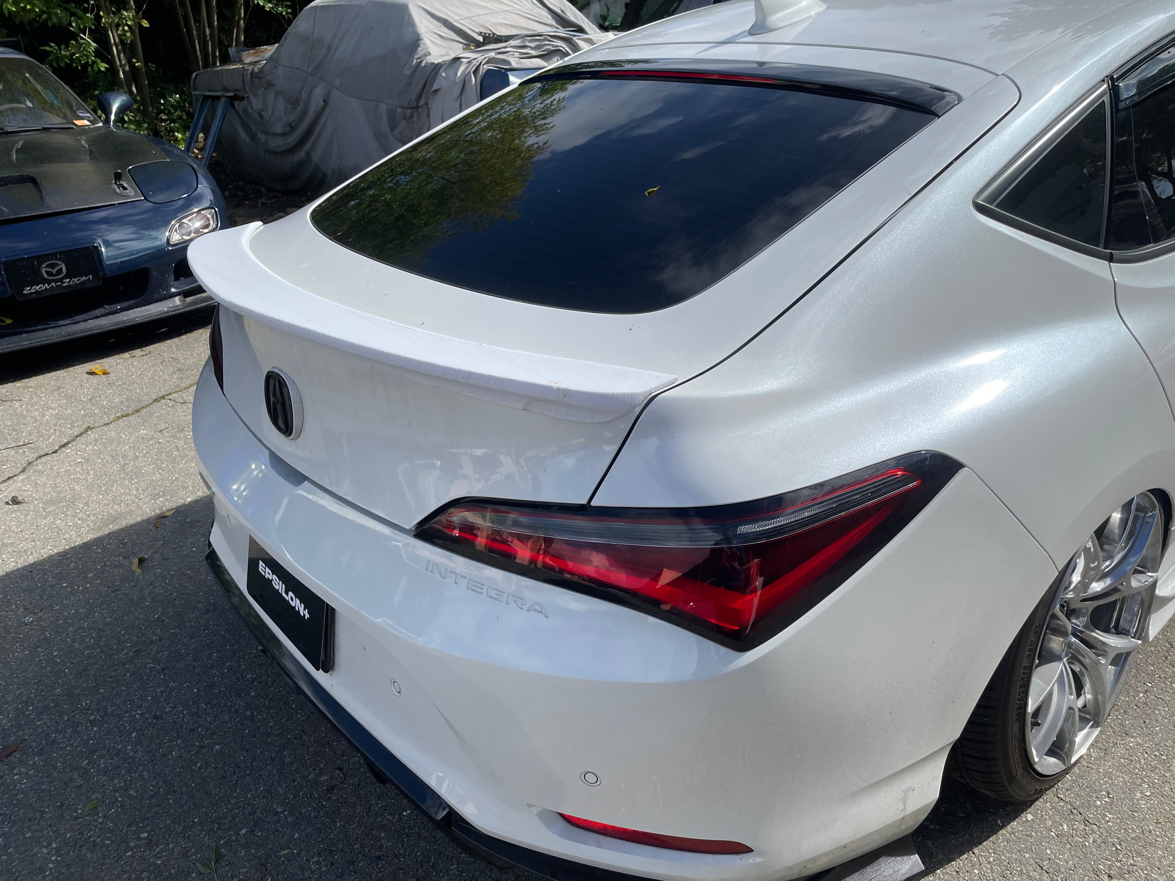 Close rear three-quarter view of the trunk lip on a white Acura Integra